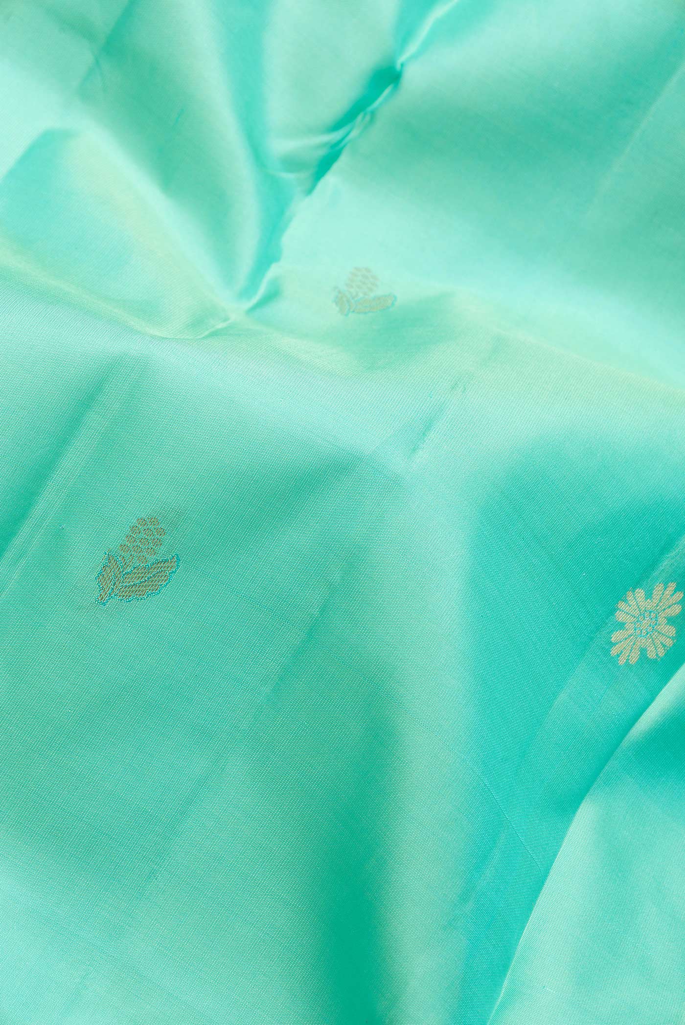 Close up of Sea Green Dual Tone Kanchipuram Silk Saree with Zari Butta on the body and Zari Border.  displaying folds