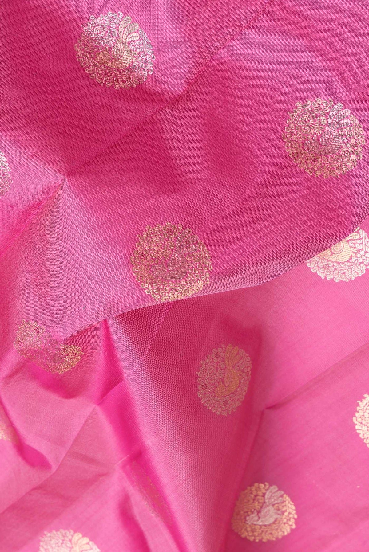 Close up of Pink Dual Tone Kanjivaram Silk Saree with Zari Butta on the body and Zari Border.  displaying folds