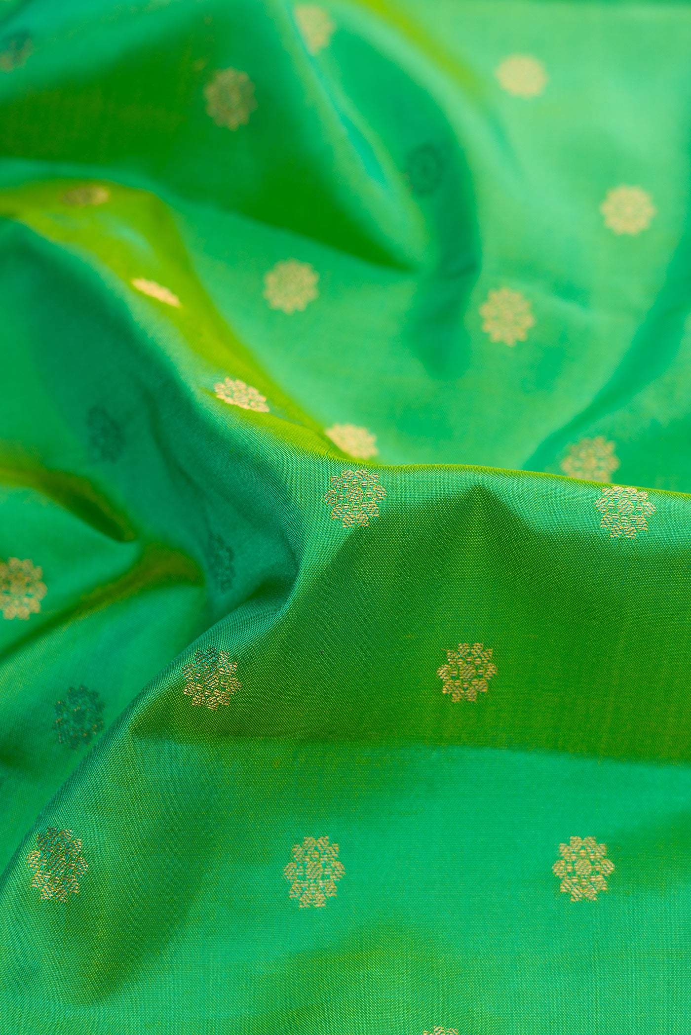 Close up of Green Dual Tone Gadwal Silk Saree with Zari Butta on the body and Zari Border.  displaying folds