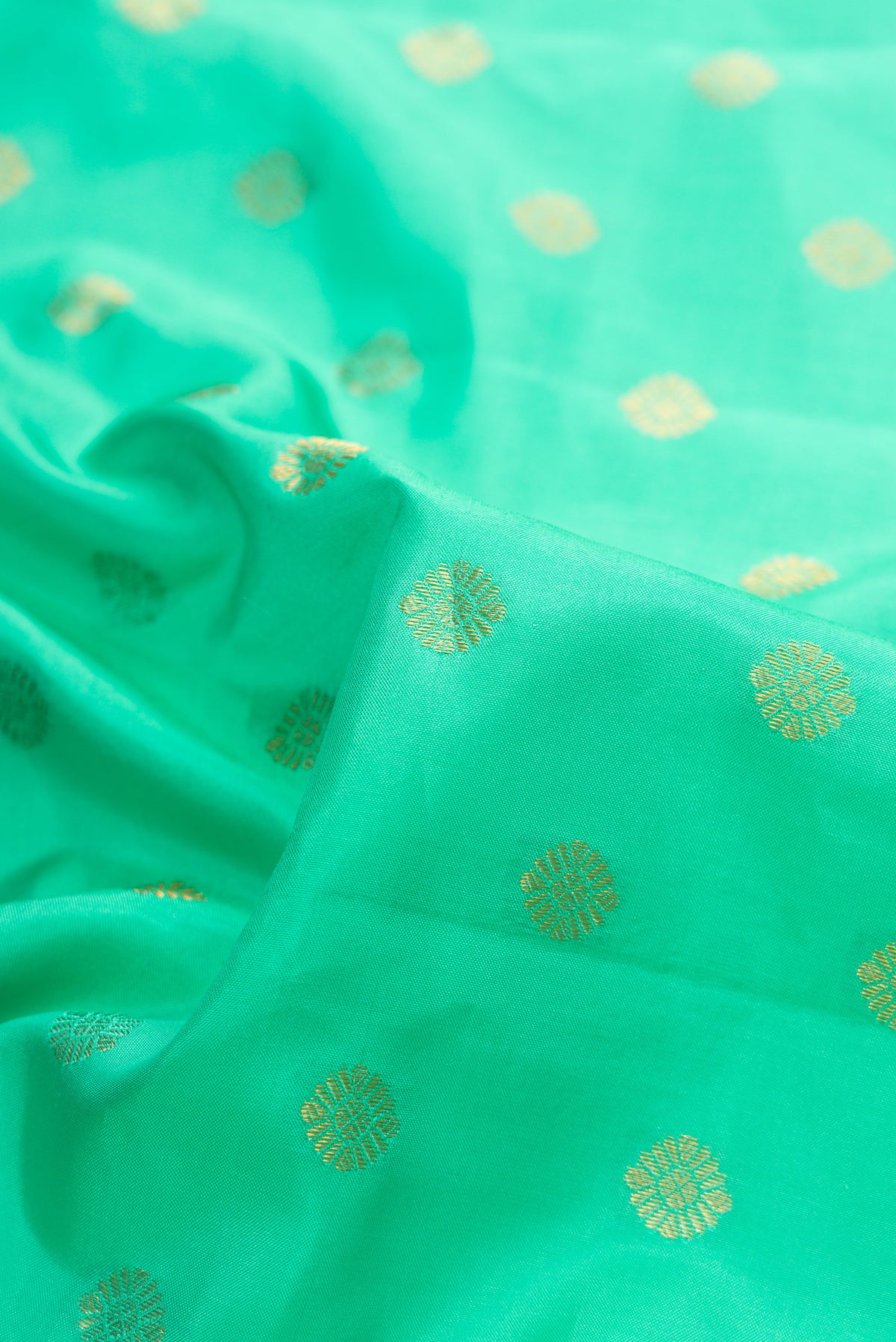 Close up of Sea Green Dual Tone Gadwal Silk Saree with Zari Butta on the body and Zari Border.  displaying folds