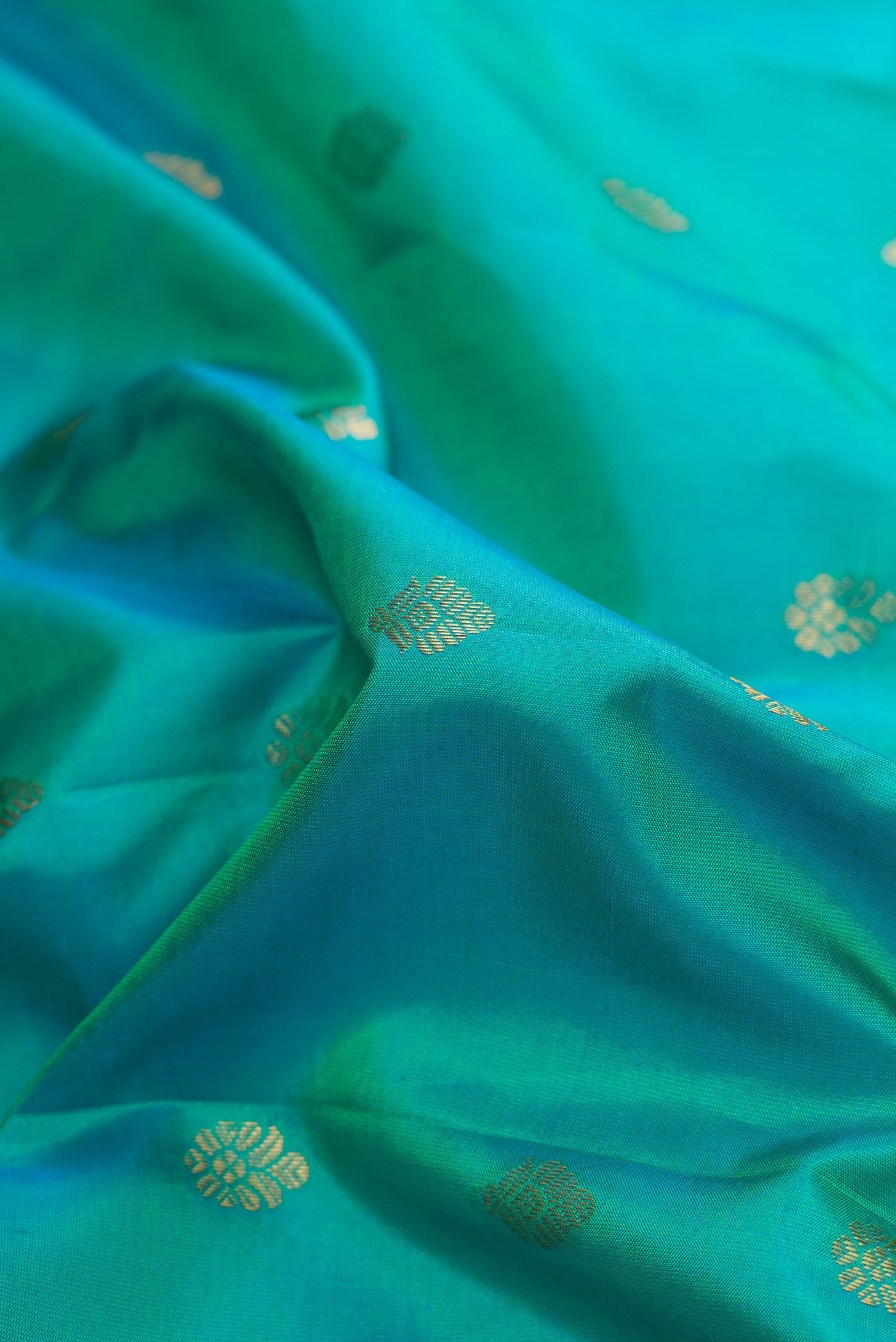 Close up of Green Dual Tone Gadwal Silk Saree with Zari Butta on the body and Zari Border.  displaying folds