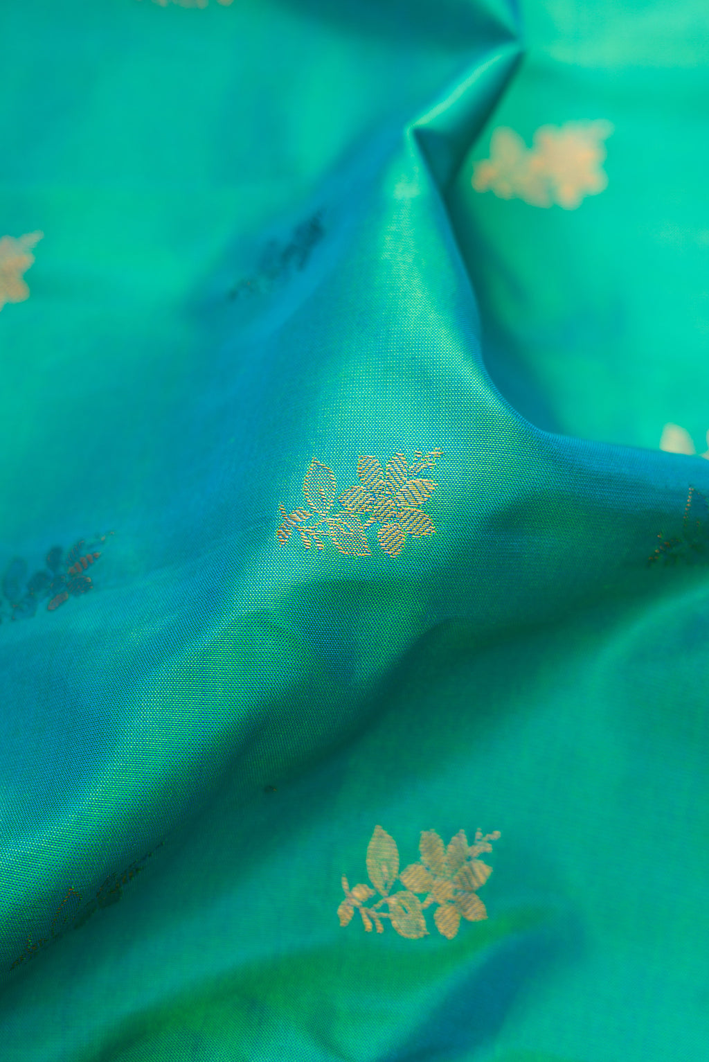 Close up of Sea Green Dual Tone Gadwal Silk Saree with Zari Butta on the body and Zari Border.  displaying folds