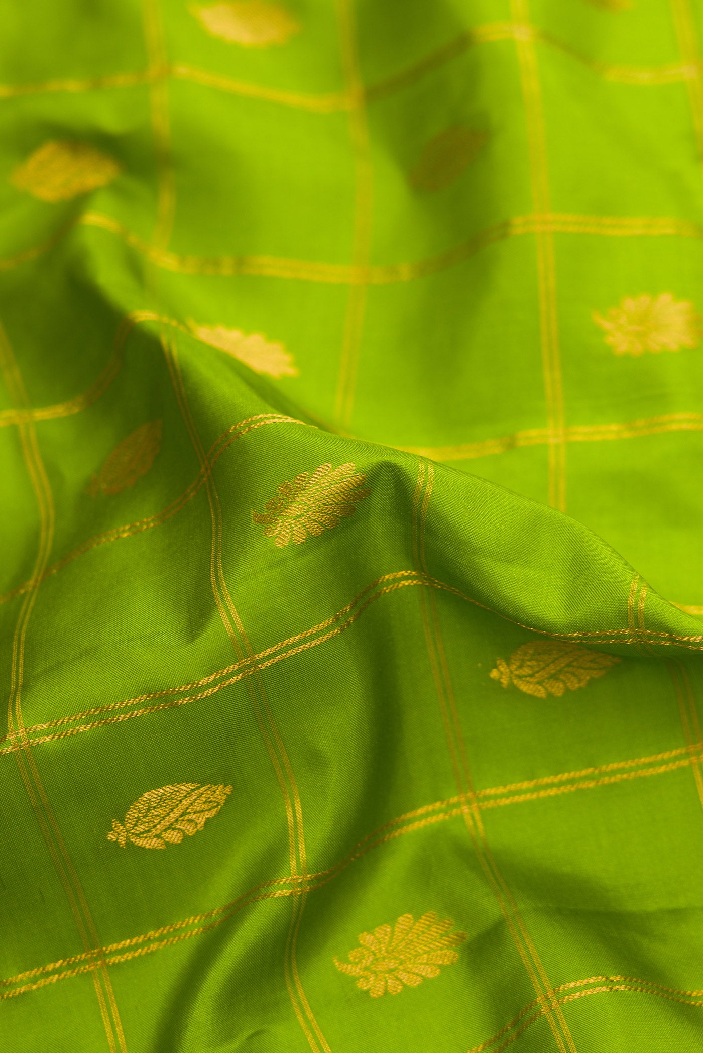 Close up of Parrot Green Dual Tone Gadwal Silk Saree with Checked design on the body and Temple Border.  displaying folds