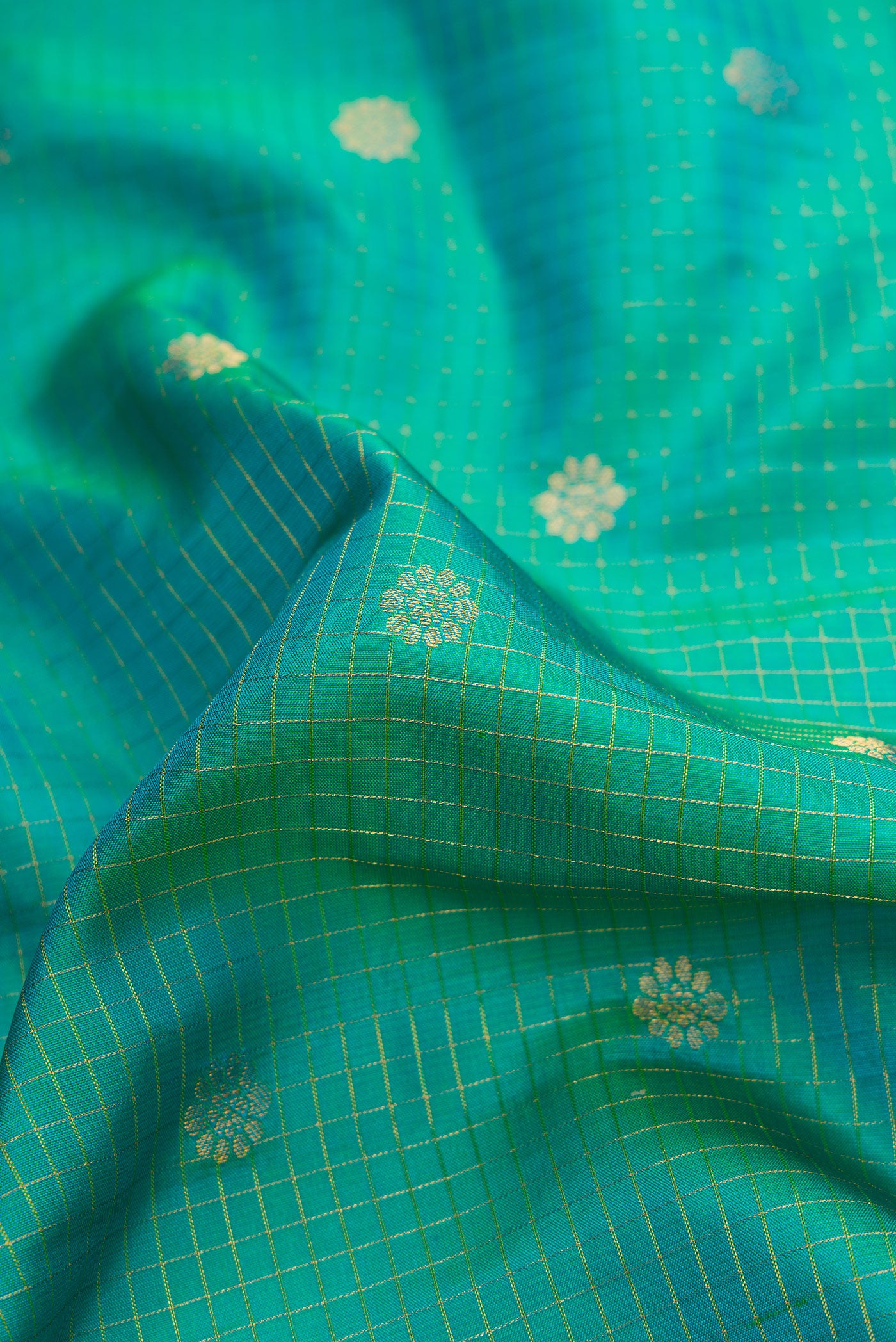 Close up of Green Dual Tone Gadwal Silk Saree with Zari Butta on the body and Zari Border.  displaying folds