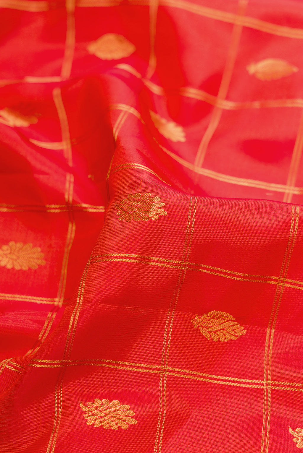 Close up of Brick Orange Dual Tone Gadwal Silk Saree with Zari Butta on the body and Zari Border.  displaying folds