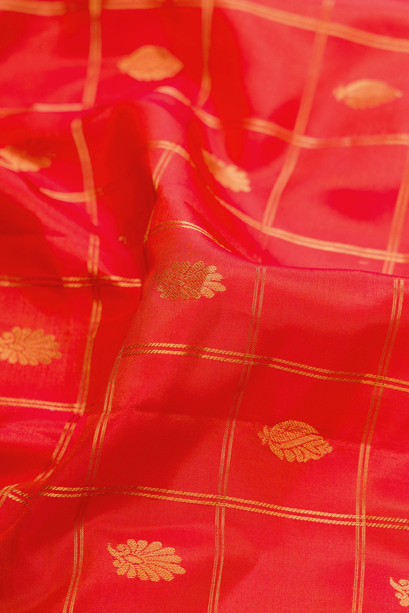Close up of Brick Orange Dual Tone Gadwal Silk Saree with Zari Butta on the body and Zari Border.  displaying folds