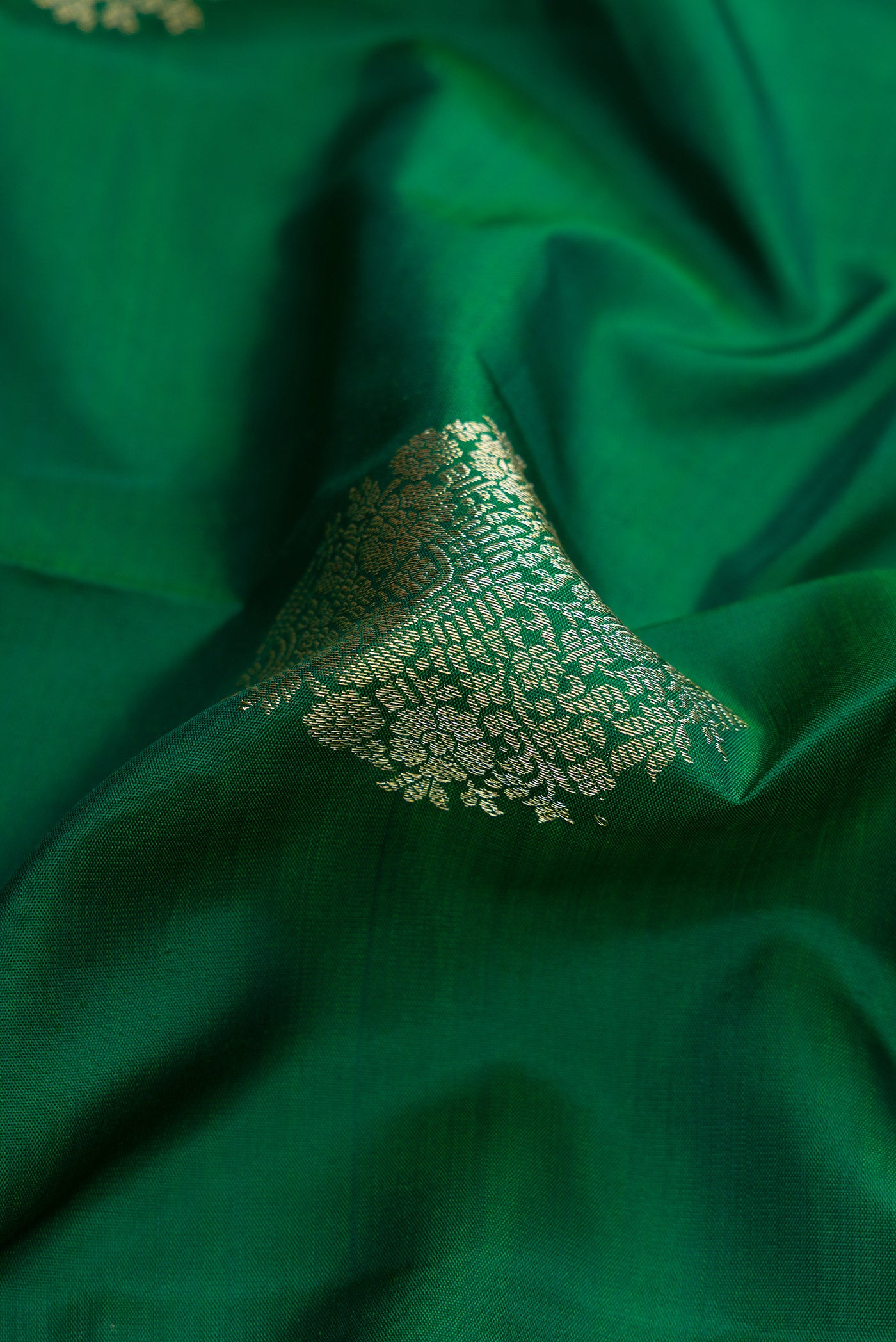 Close up of Bottle Green Dual Tone Kanjivaram Silk Saree with Zari Butta on the body and Zari Border.  displaying folds