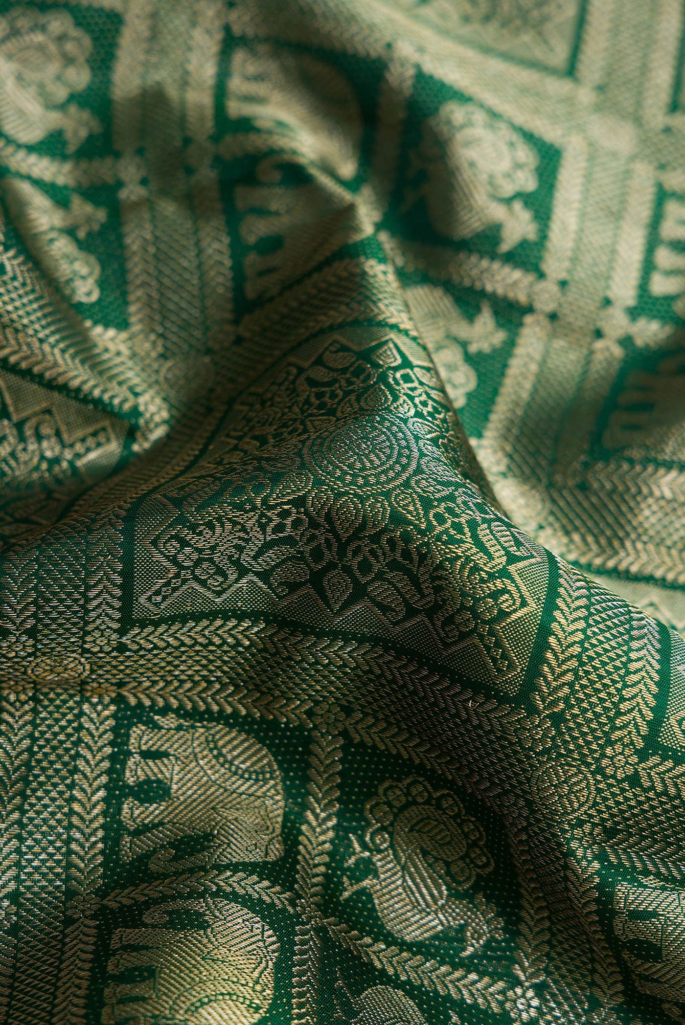 Close up of Green Dual Tone Kanchipuram Silk Saree with Zari Brocade on the body and Fancy Border.  displaying folds