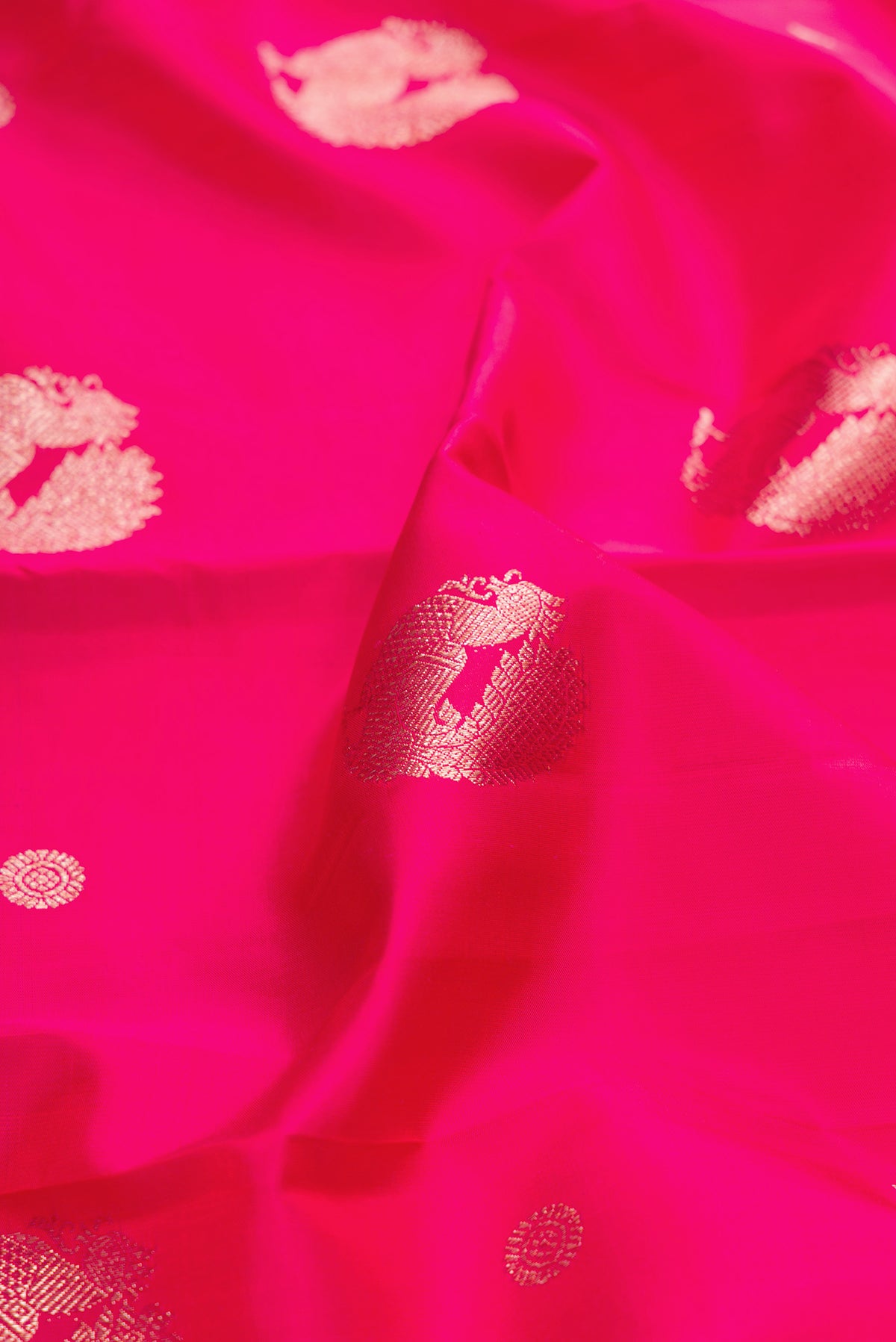Close up of Pink Dual Tone Kanjivaram Silk Saree with Zari Butta on the body and Zari Border.  displaying folds