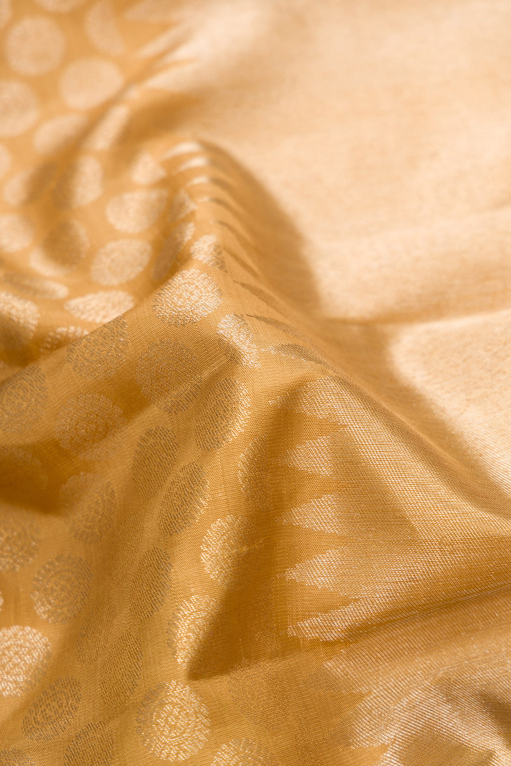 Close up of Gold Dual Tone Kanchipuram Silk Saree with Zari Brocade on the body and Temple Border.  displaying folds