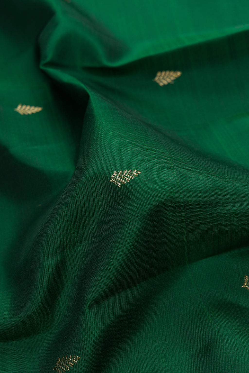 Close up of Bottle Green Dual Tone Kanjivaram Silk Saree with Zari Butta on the body and Fancy Border.  displaying folds