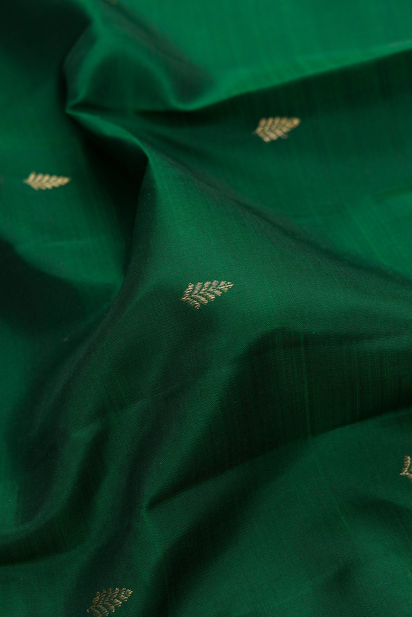 Close up of Bottle Green Dual Tone Kanjivaram Silk Saree with Zari Butta on the body and Fancy Border.  displaying folds