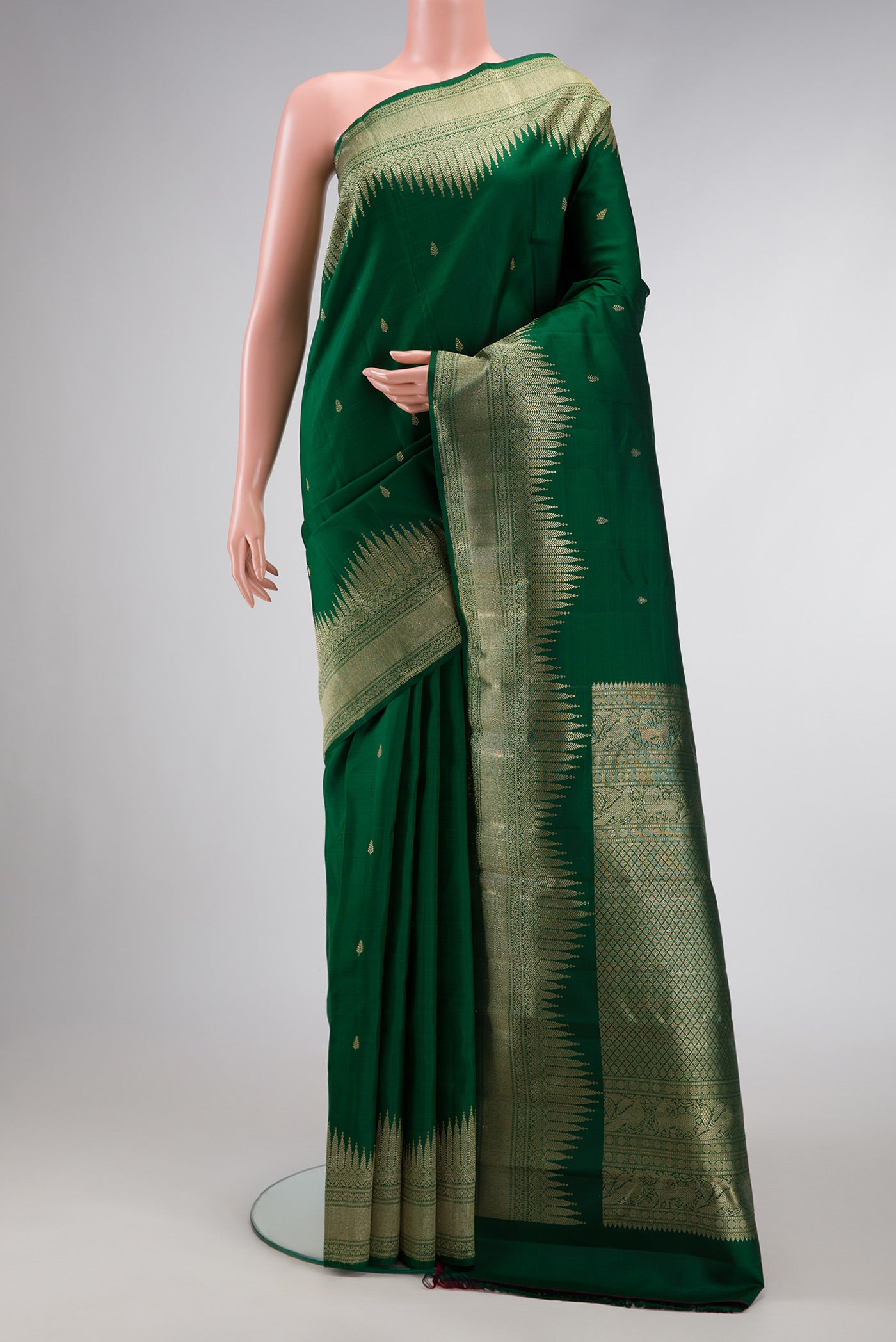 Bottle Green Dual Tone Kanjivaram Silk Saree with Zari Butta on the body and Fancy Border.  displayed on a mannequin