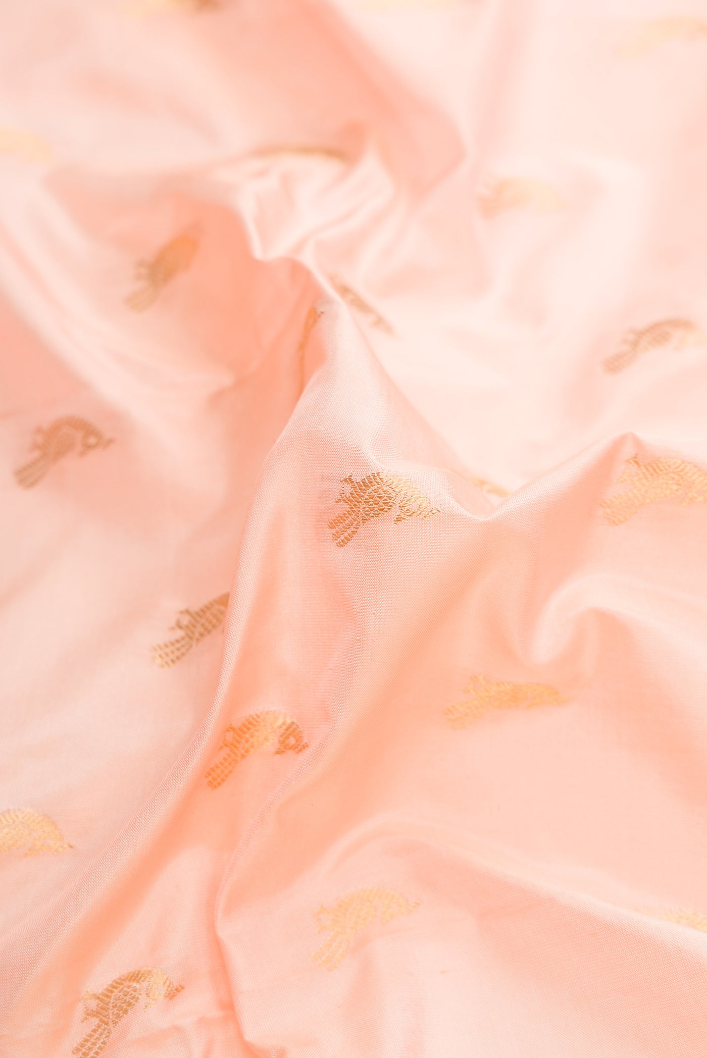 Close up of Peach Dual Tone Paithani Silk Saree with Zari Butta on the body and Paithani Border.  displaying folds
