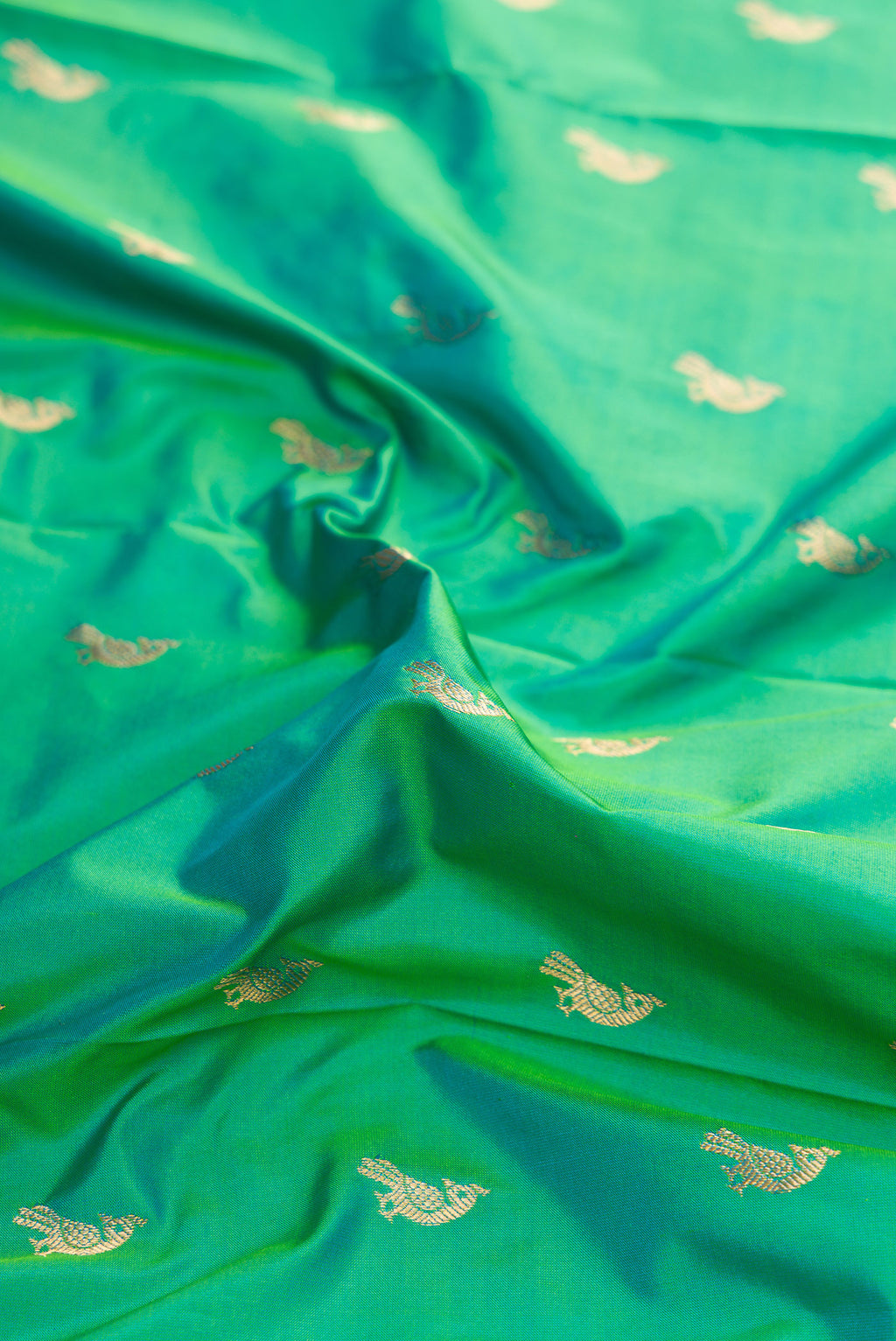Close up of Green Dual Tone Paithani Silk Saree with Zari Butta on the body and Paithani Border.  displaying folds