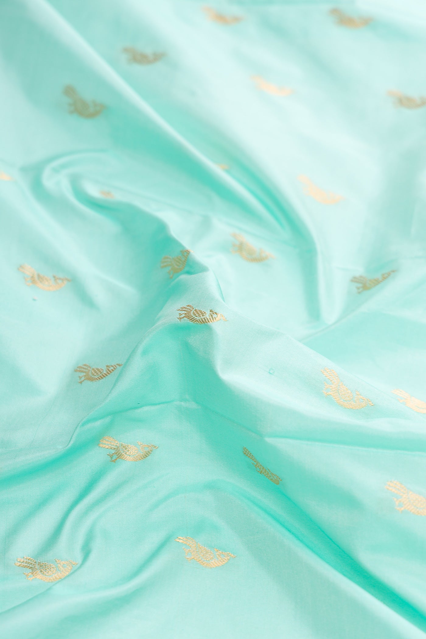 Close up of Light Blue Dual Tone Paithani Silk Saree with Zari Butta on the body and Paithani Border.  displaying folds