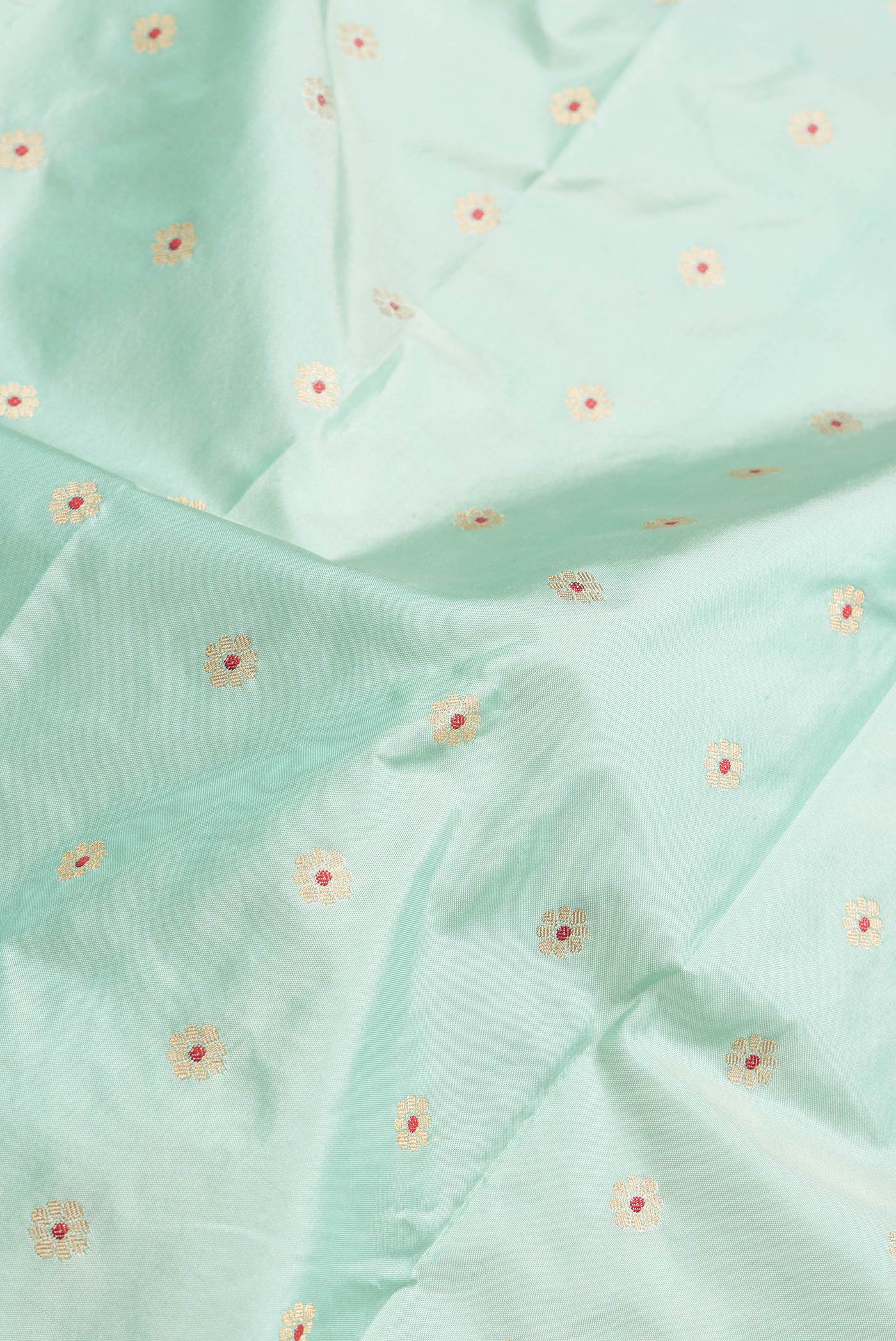 Close up of Sea Green Dual Tone Paithani Silk Saree with Zari And Thread Butta on the body and Paithani Border.  displaying folds