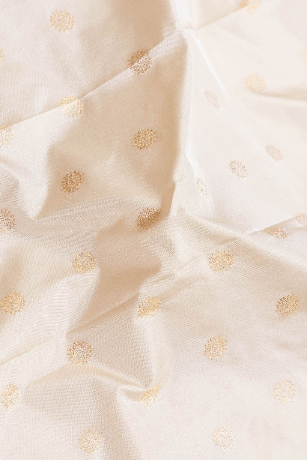 Close up of Beige Dual Tone Paithani Silk Saree with Zari Butta on the body and Paithani Border.  displaying folds
