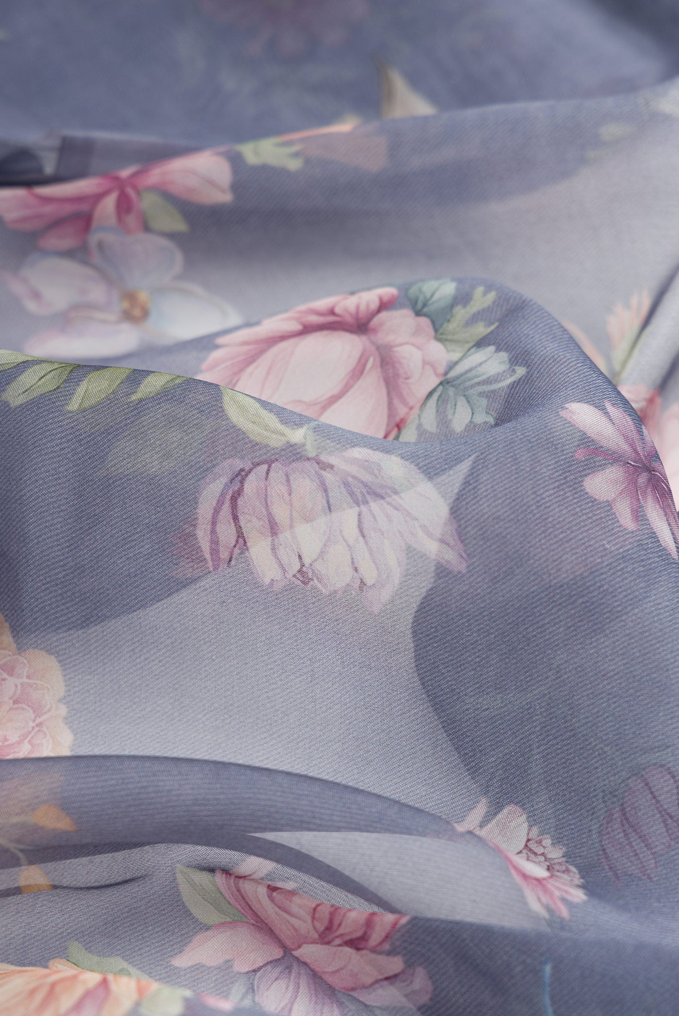 Close up of Grey Dual Tone Organza Silk Saree with Printed design on the body and Without Border.  displaying folds