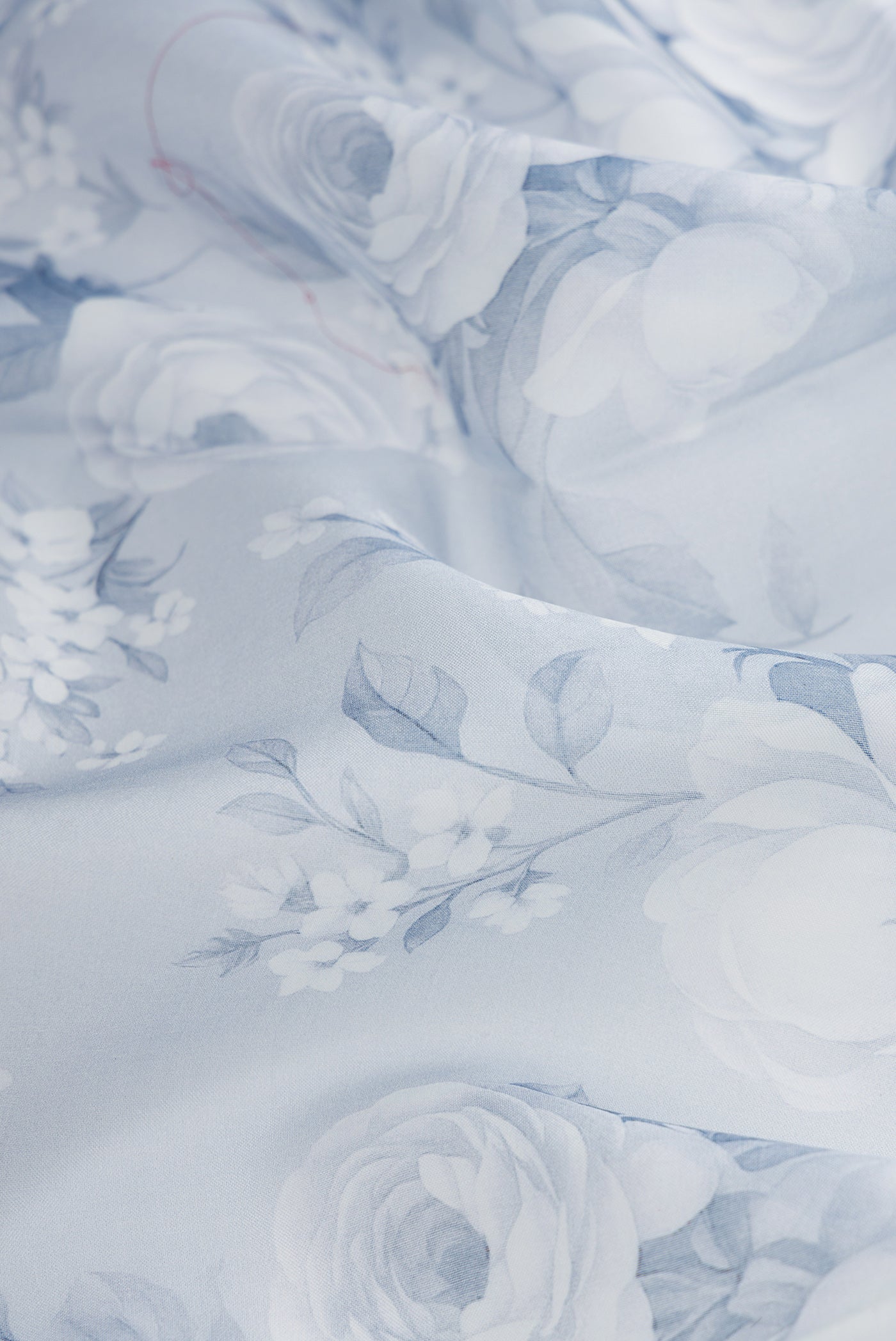 Close up of Grey Dual Tone Organza Silk Saree with Printed design on the body and Plain Border.  displaying folds