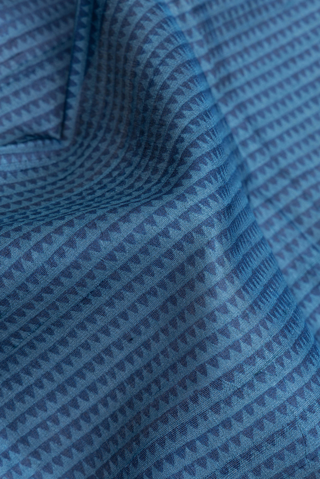 Close up of Peacock Blue Dual Tone Tussar Silk Saree with Printed design on the body and Fancy Border.  displaying folds