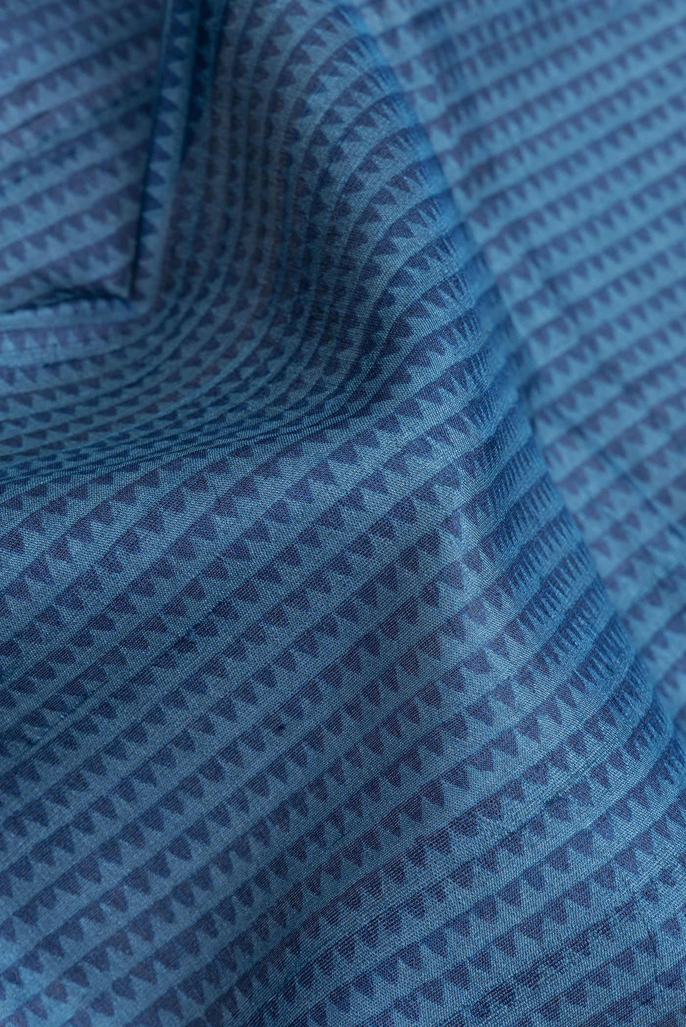 Close up of Peacock Blue Dual Tone Tussar Silk Saree with Printed design on the body and Fancy Border.  displaying folds