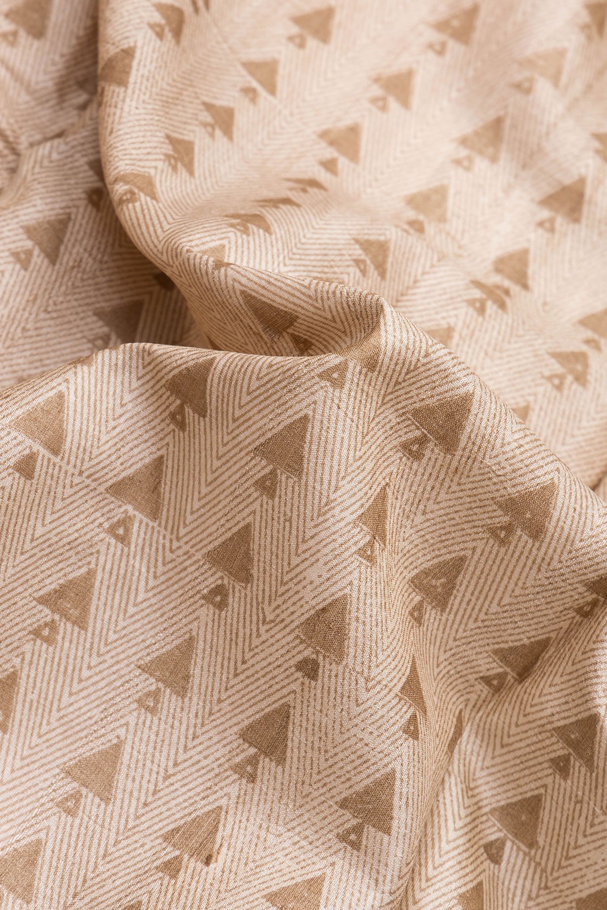 Close up of Beige Dual Tone Tussar Silk Saree with Printed design on the body and Printed Border.  displaying folds