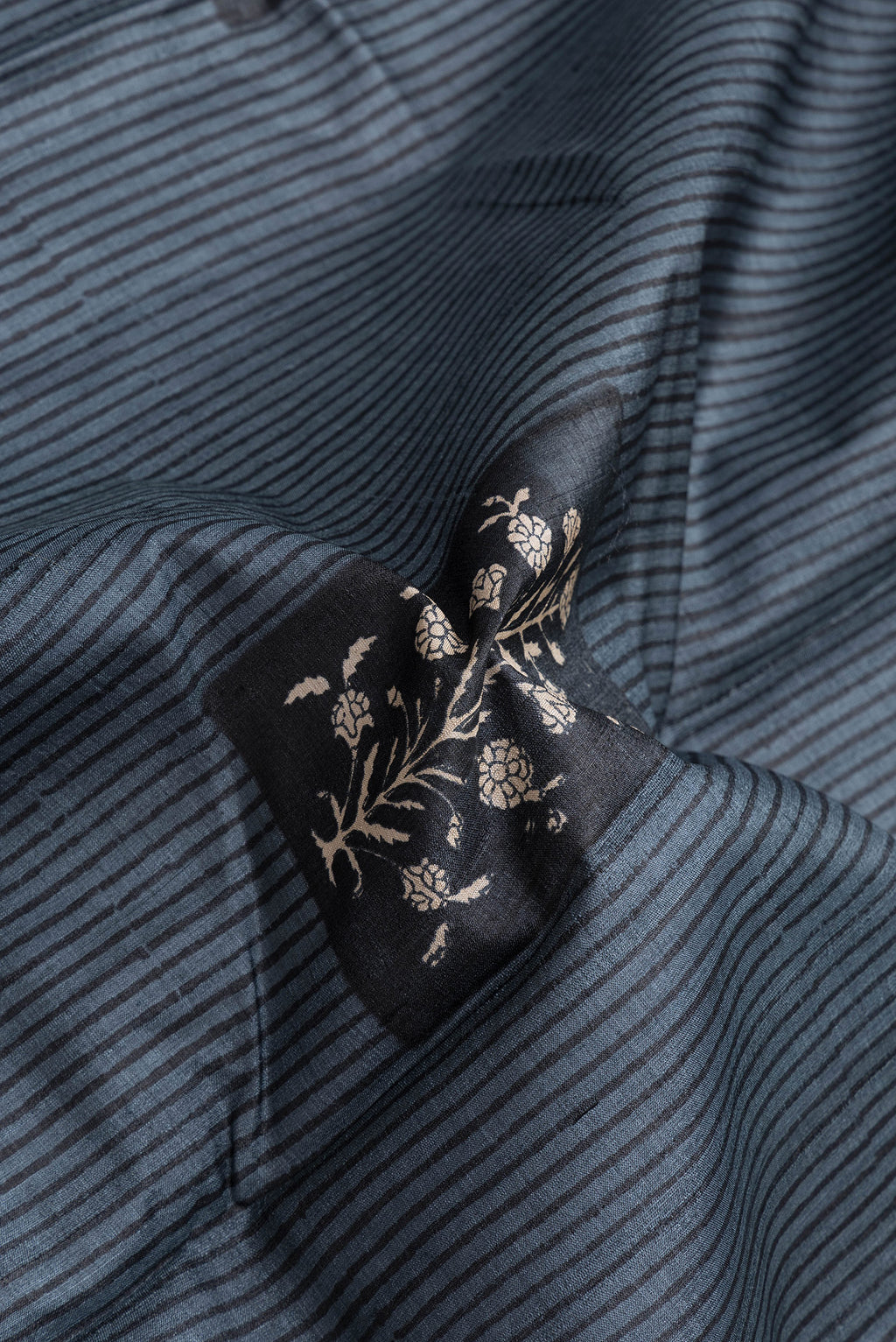 Close up of Grey Dual Tone Tussar Silk Saree with Printed design on the body and Printed Border.  displaying folds