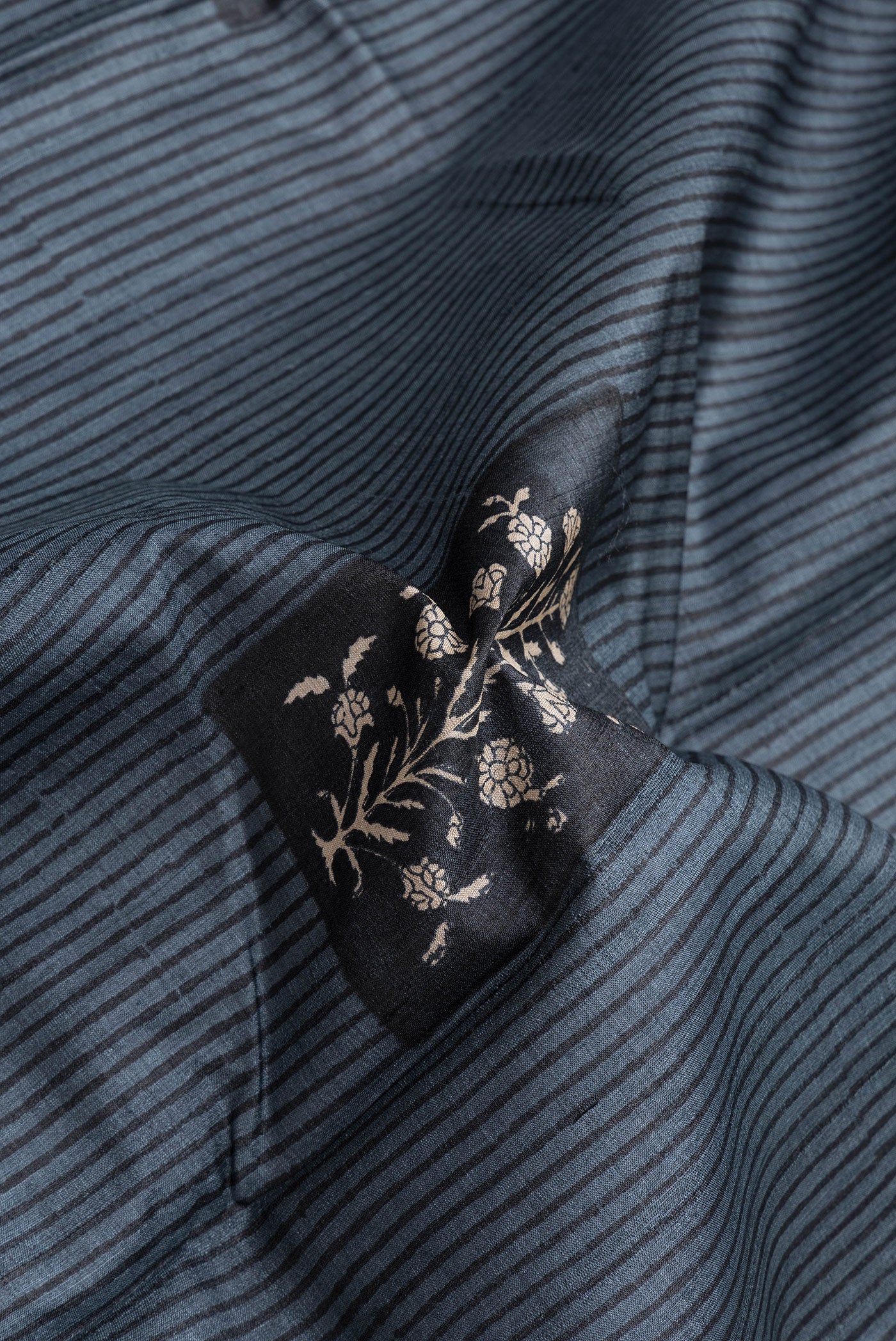 Close up of Grey Dual Tone Tussar Silk Saree with Printed design on the body and Printed Border.  displaying folds