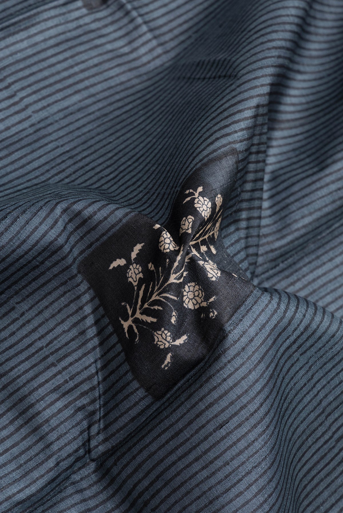 Close up of Grey Dual Tone Tussar Silk Saree with Printed design on the body and Printed Border.  displaying folds