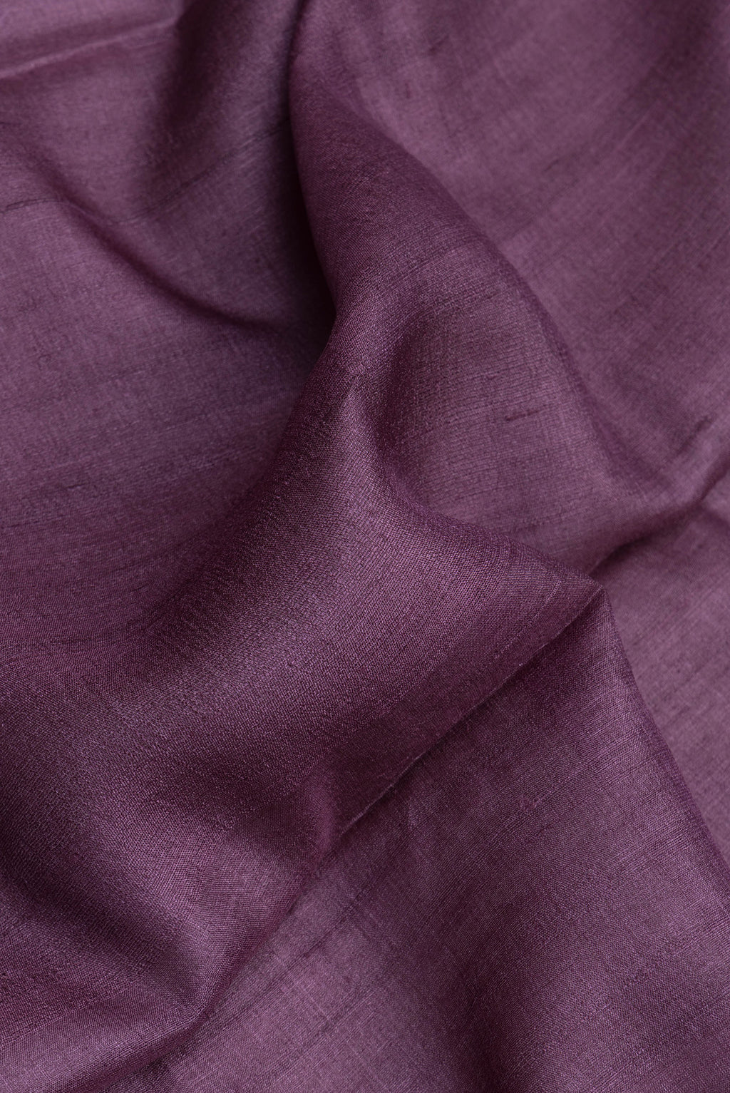 Close up of Purple Dual Tone Tussar Silk Saree with Plain Body and Fancy Border.  displaying folds