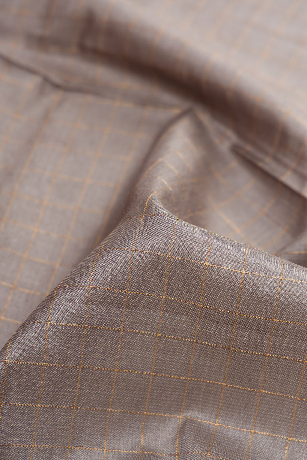 Close up of Grey Dual Tone Tussar Silk Saree with Checked design on the body and Printed Border.  displaying folds