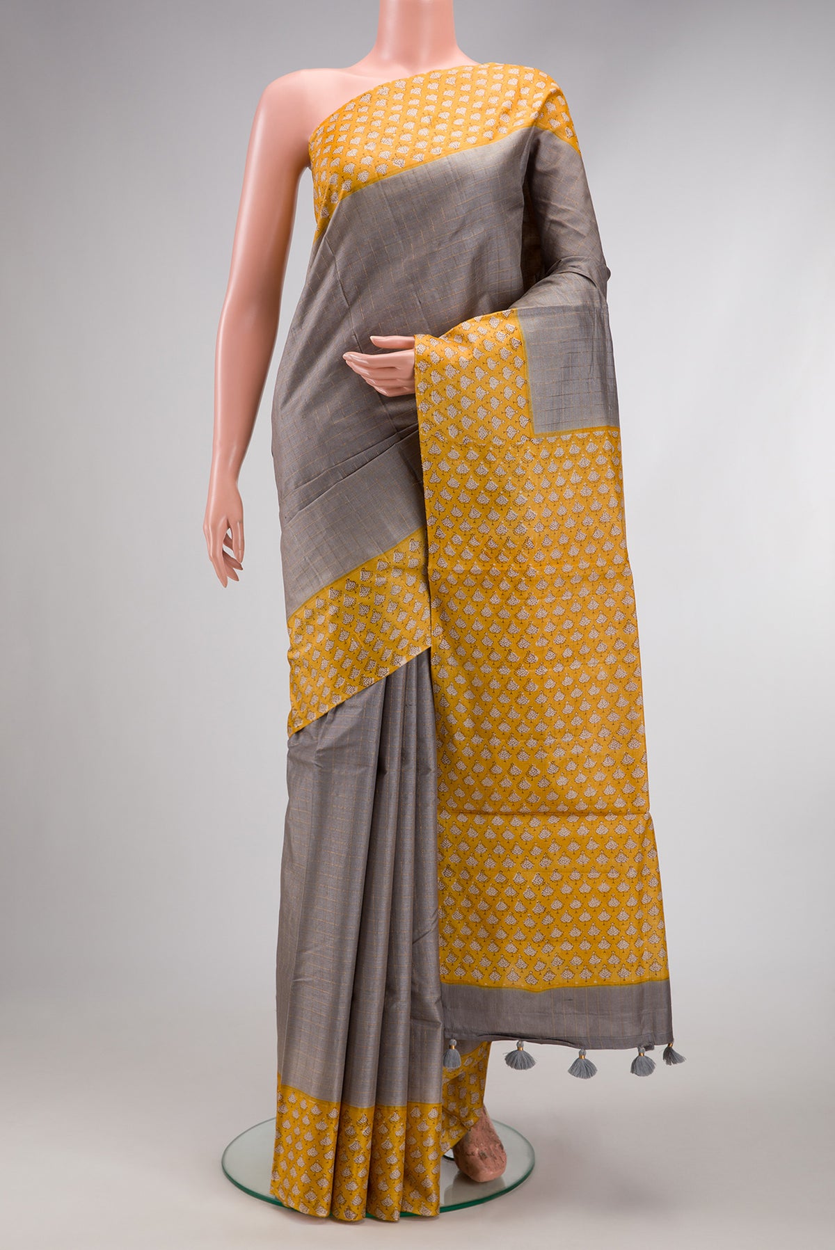 Grey Dual Tone Tussar Silk Saree with Checked design on the body and Printed Border.  displayed on a mannequin