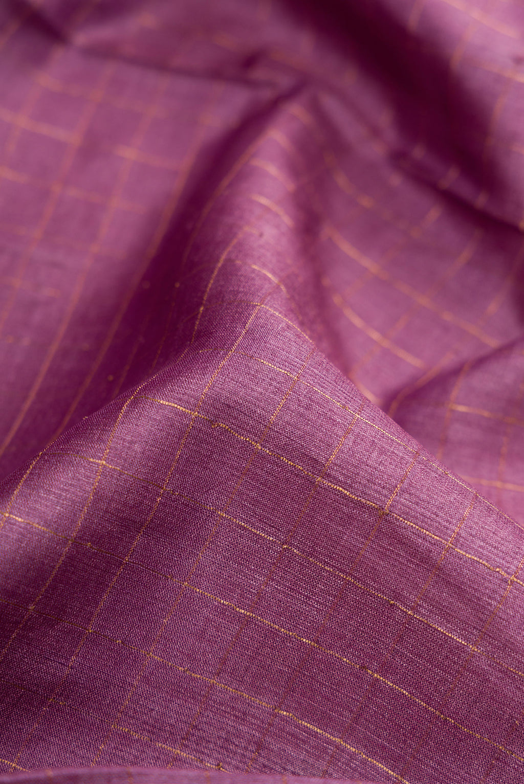 Close up of Lavender Dual Tone Tussar Silk Saree with Checked design on the body and Printed Border.  displaying folds