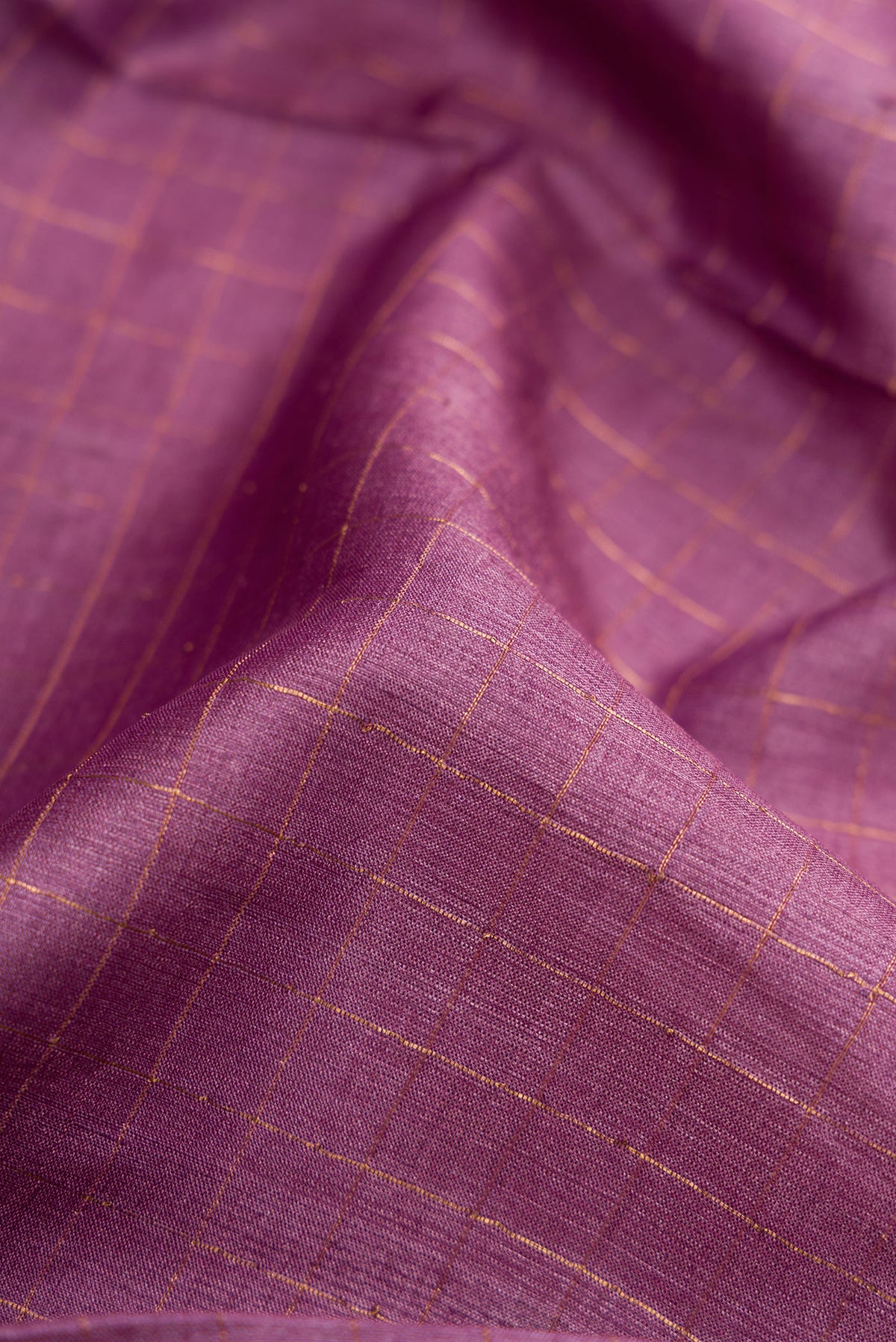 Close up of Lavender Dual Tone Tussar Silk Saree with Checked design on the body and Printed Border.  displaying folds