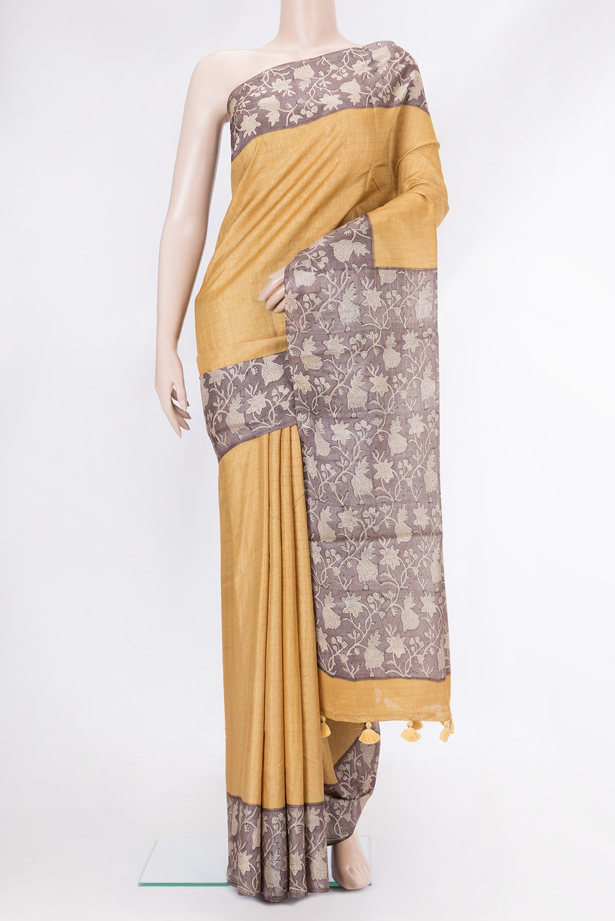 Gold Dual Tone Tussar Silk Saree with Checked design on the body and Printed Border.  displayed on a mannequin