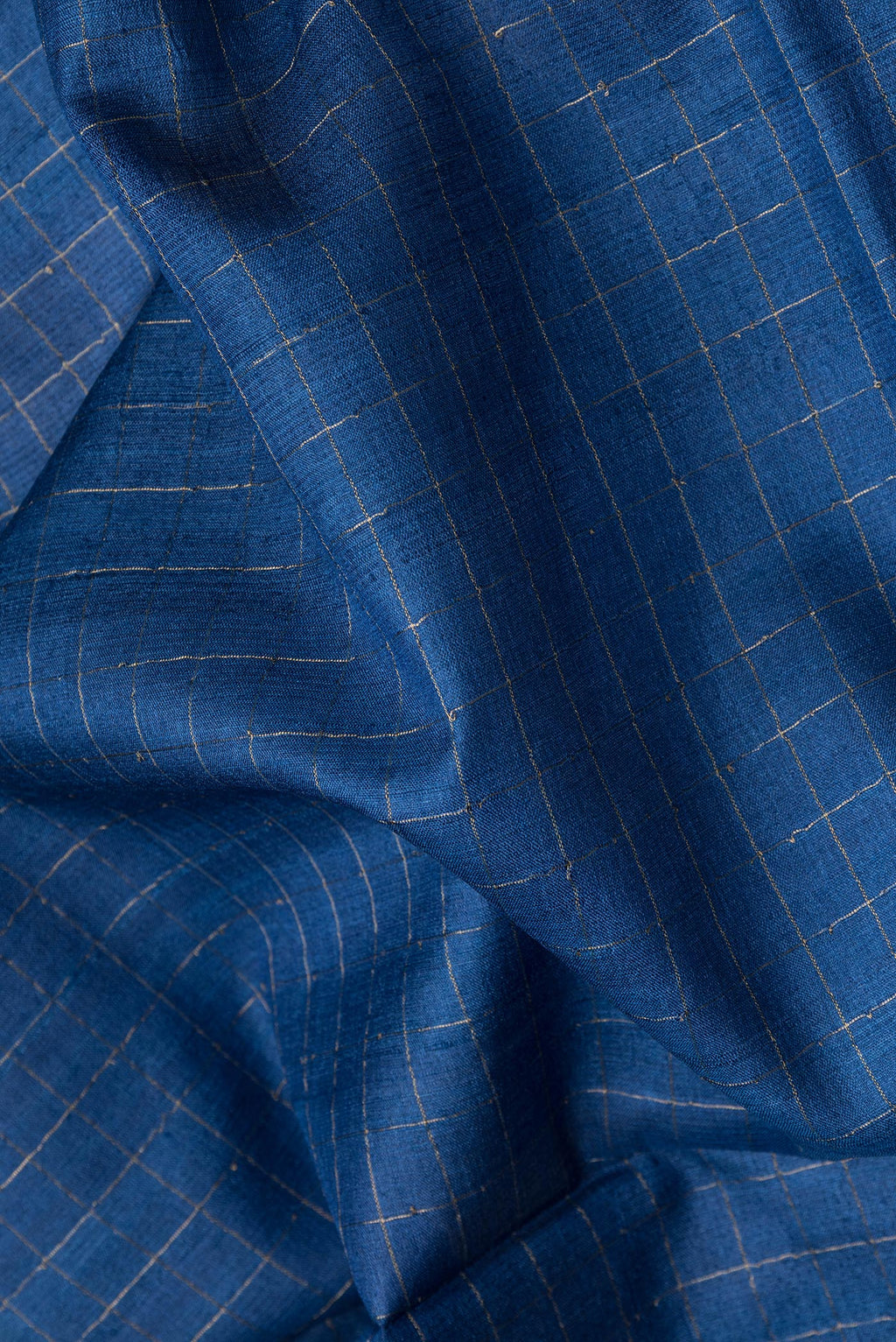 Close up of Royal Blue Dual Tone Tussar Silk Saree with Checked design on the body and Printed Border.  displaying folds