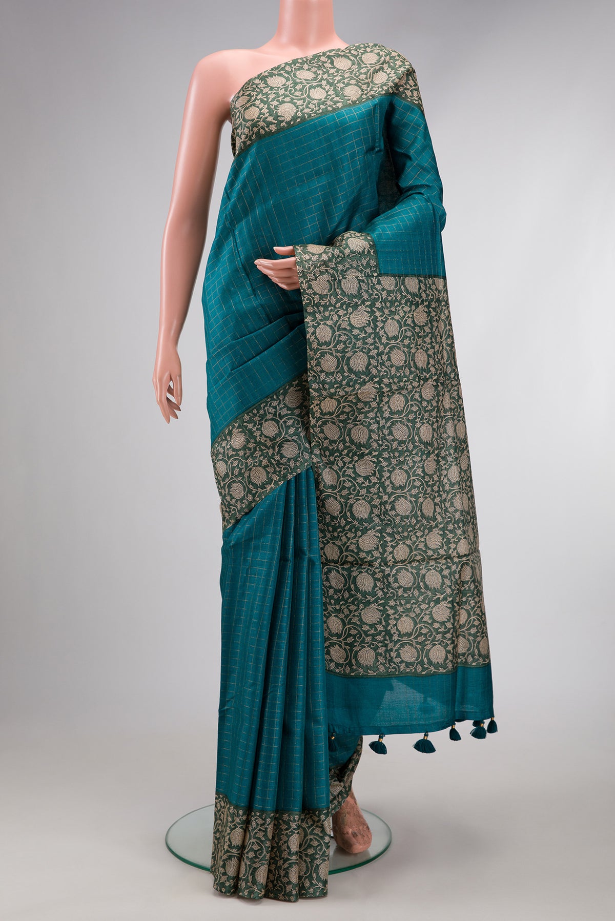 Peacock Blue Dual Tone Tussar Silk Saree with Checked design on the body and Printed Border.  displayed on a mannequin