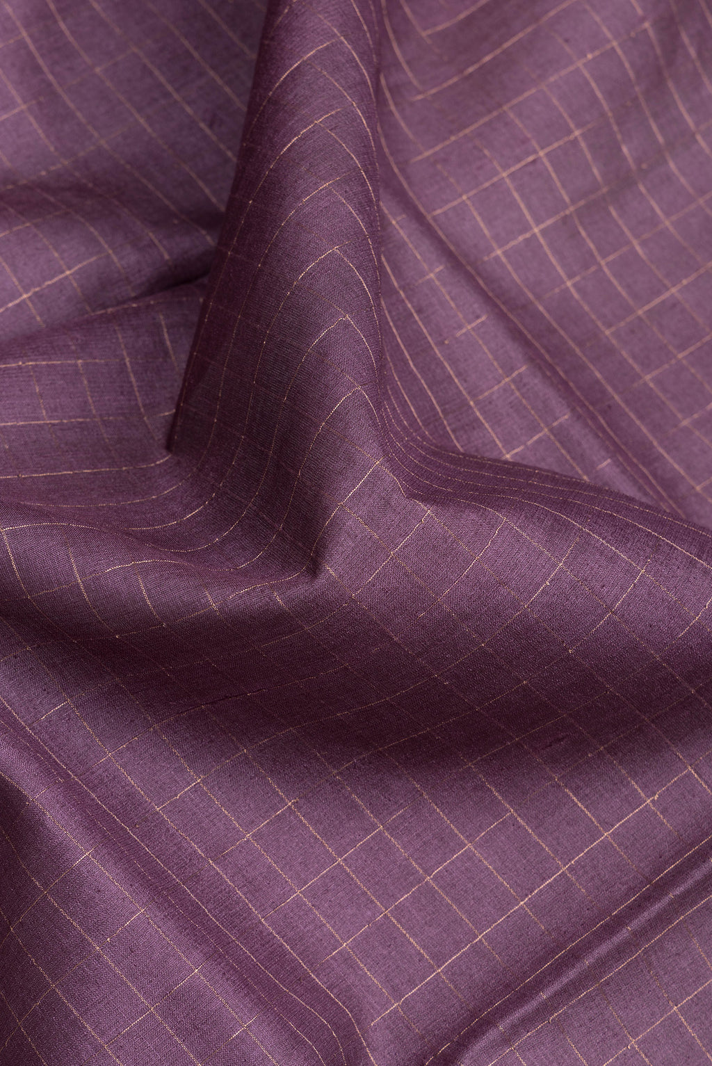 Close up of Purple Dual Tone Tussar Silk Saree with Checked design on the body and Printed Border.  displaying folds