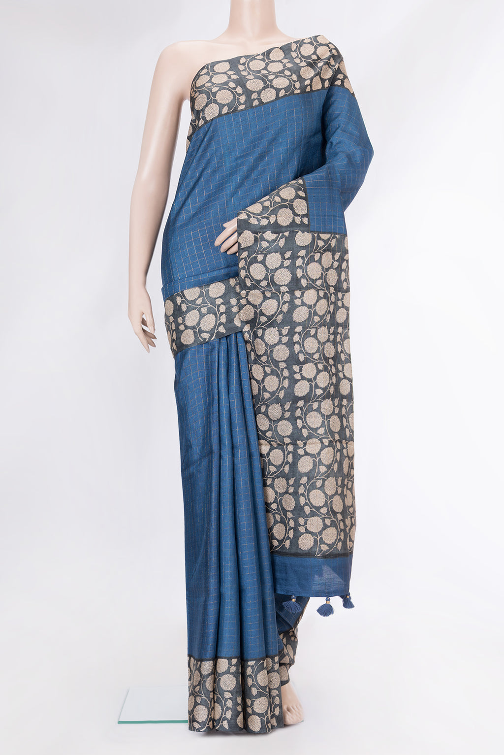 Peacock Blue Tussar Silk Saree with Checked design on the body and Printed Border.  displayed on a mannequin