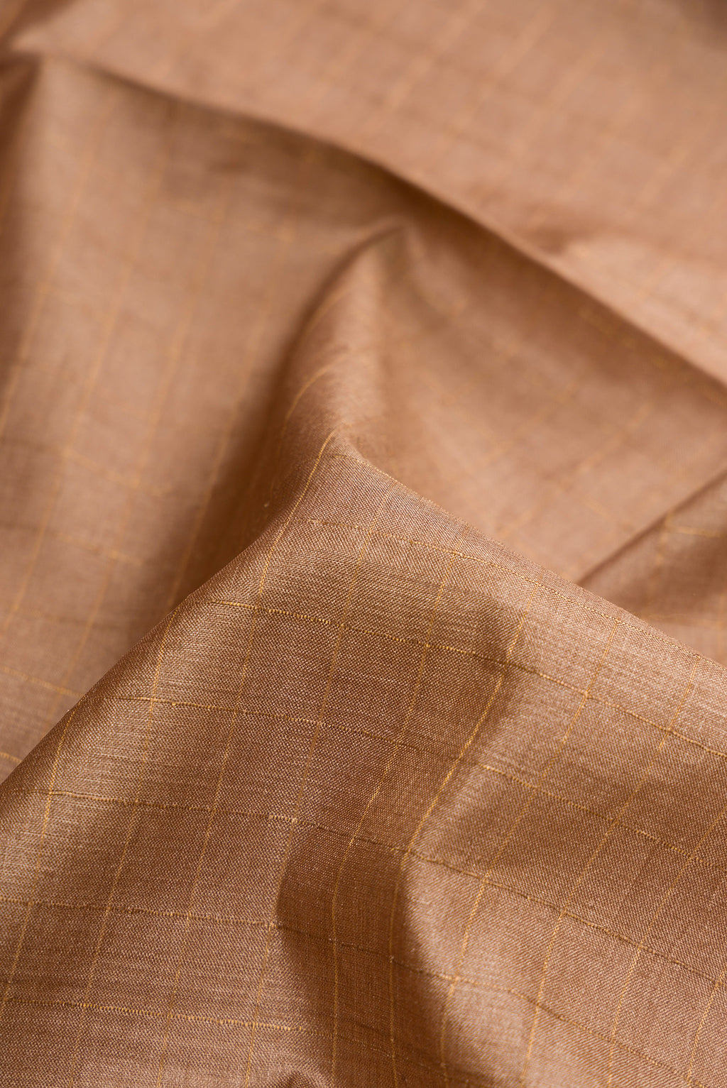 Close up of Brown Dual Tone Tussar Silk Saree with Checked design on the body and Printed Border.  displaying folds