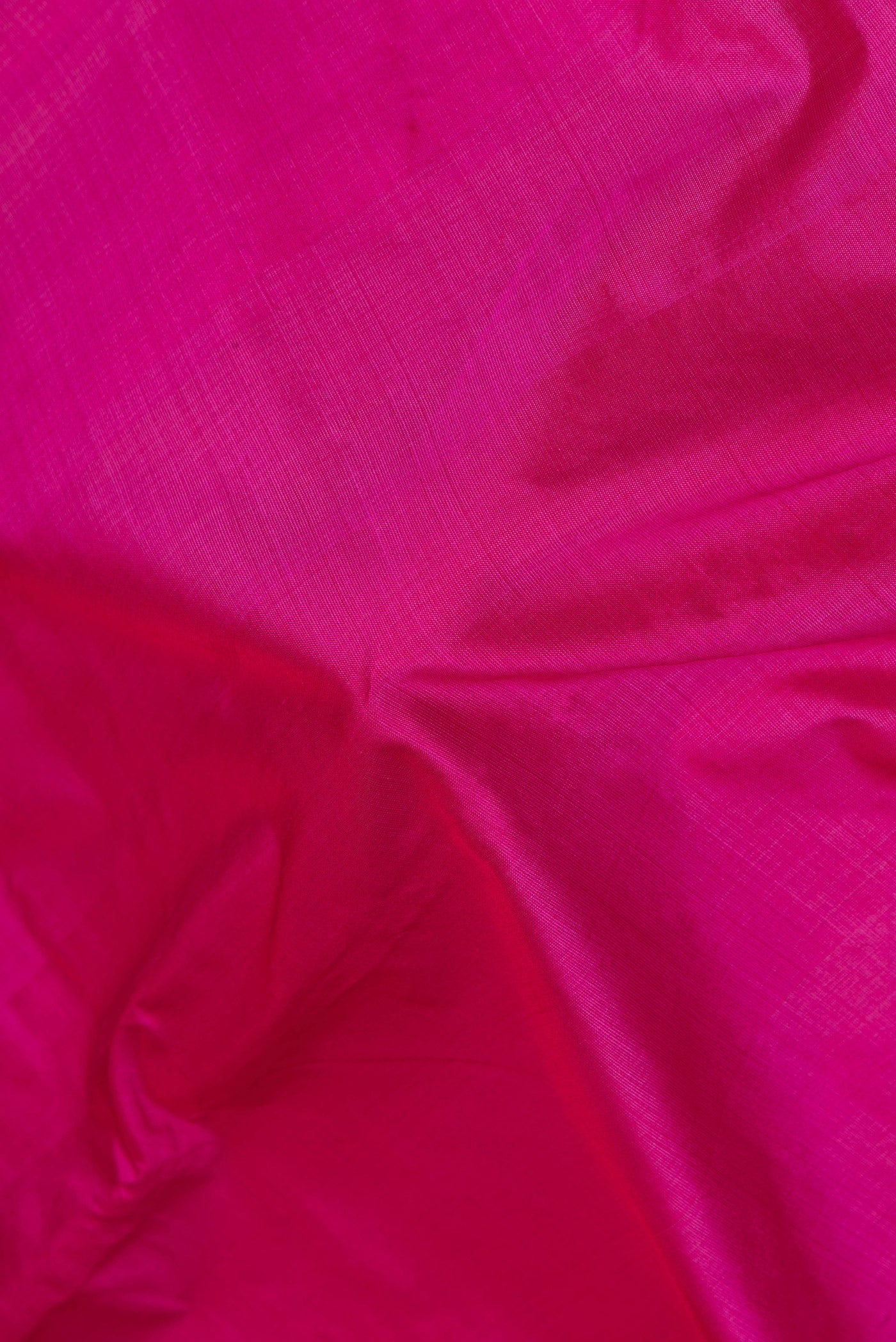 Close up of Magenta Kanchipuram Silk Saree with Plain Body and Zari Border.  displaying folds