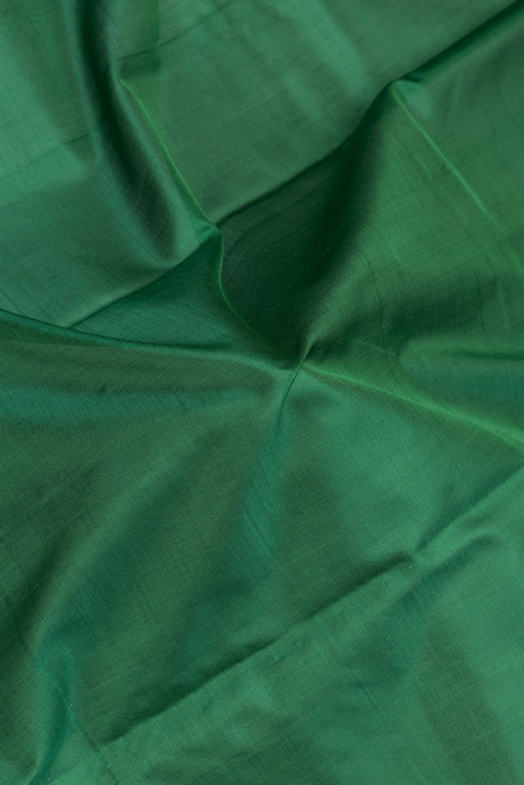 Close up of Bottle Green Kanchipuram Silk Saree with Plain Body and Thread Border.  displaying folds