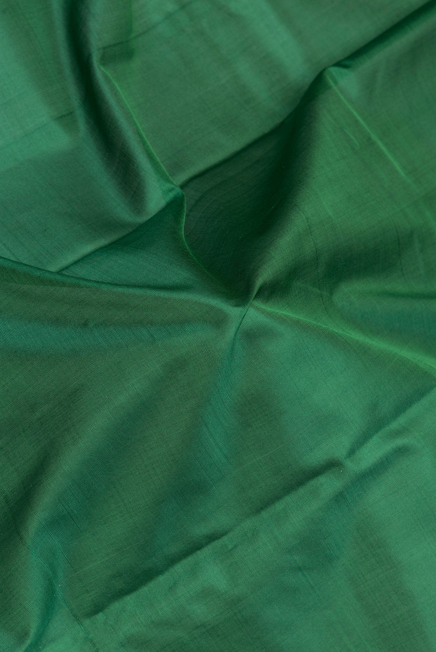 Close up of Bottle Green Kanchipuram Silk Saree with Plain Body and Thread Border.  displaying folds
