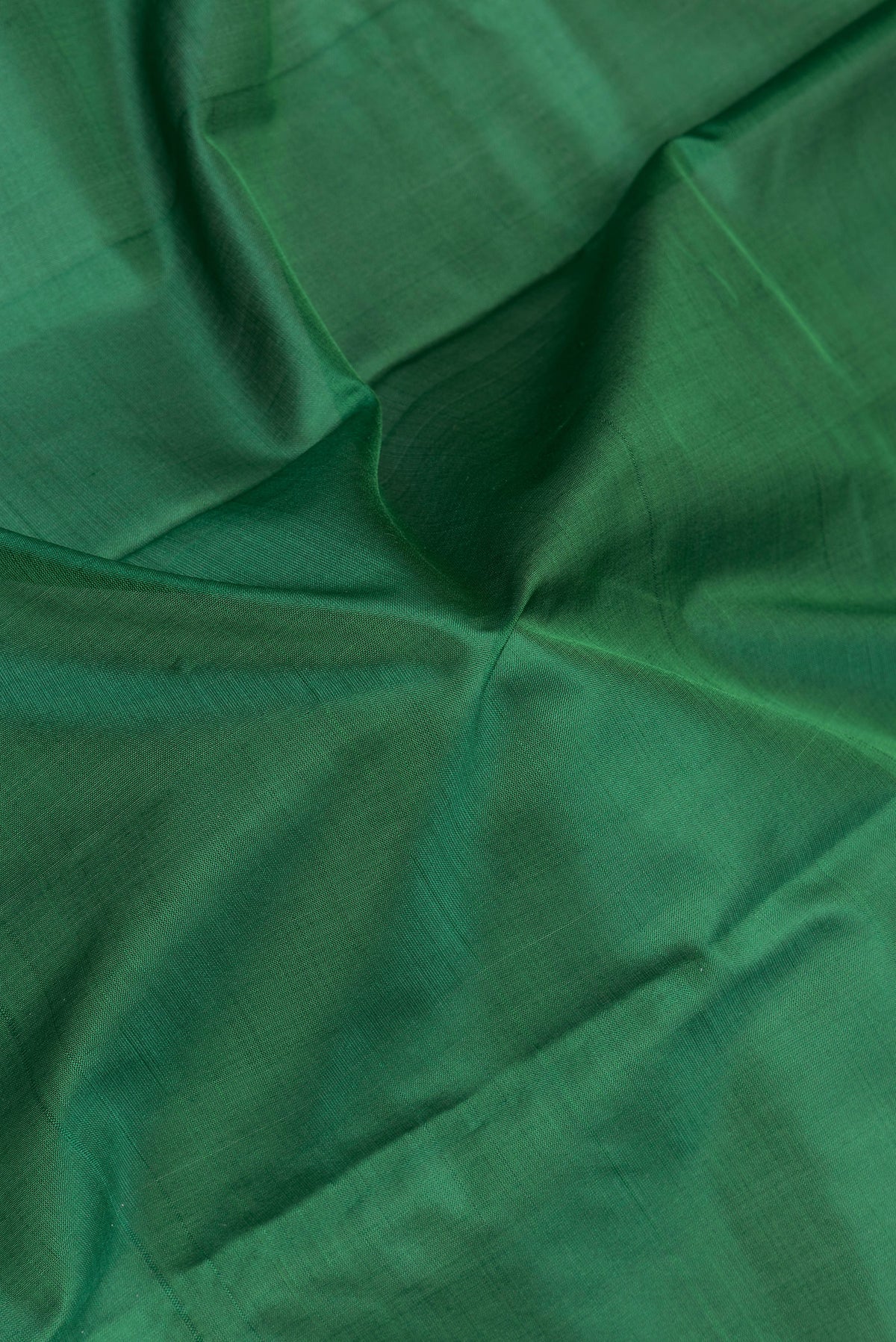 Close up of Bottle Green Kanchipuram Silk Saree with Plain Body and Thread Border.  displaying folds
