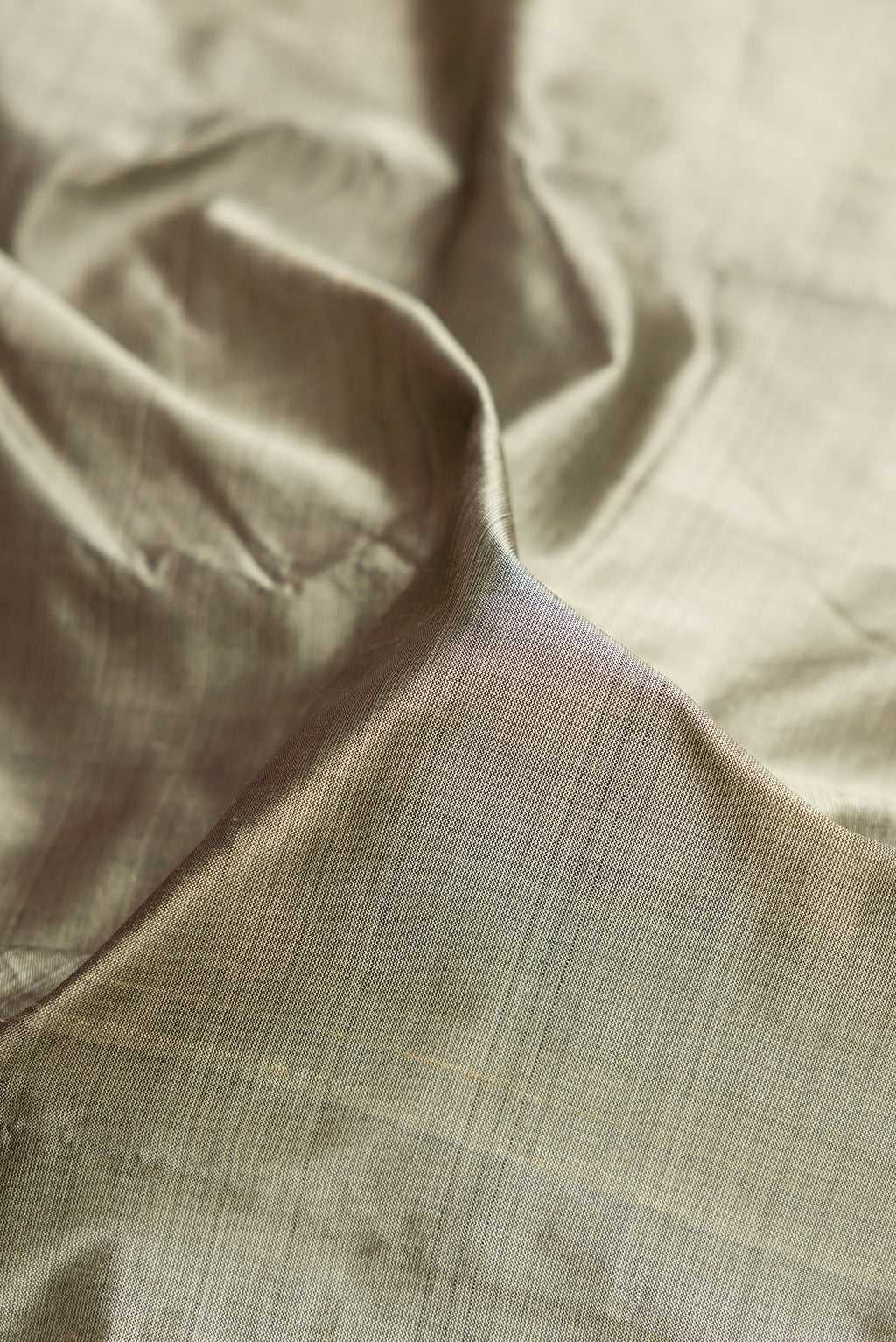Close up of Grey Dual Tone Kanjivaram Silk Saree with Plain Body and Zari Border.  displaying folds