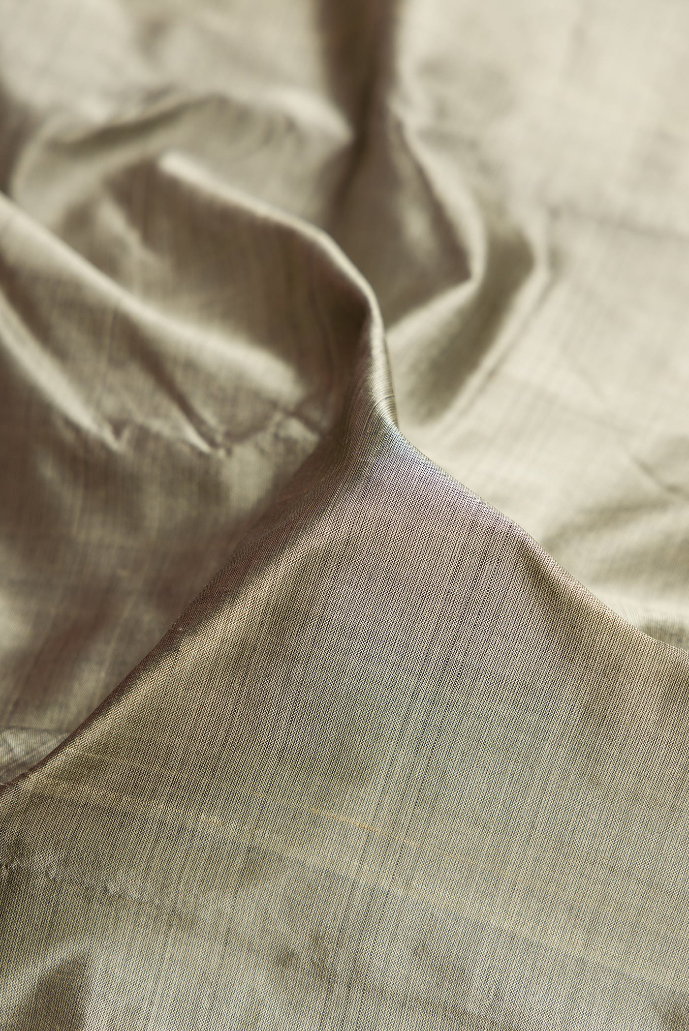 Close up of Grey Dual Tone Kanjivaram Silk Saree with Plain Body and Zari Border.  displaying folds