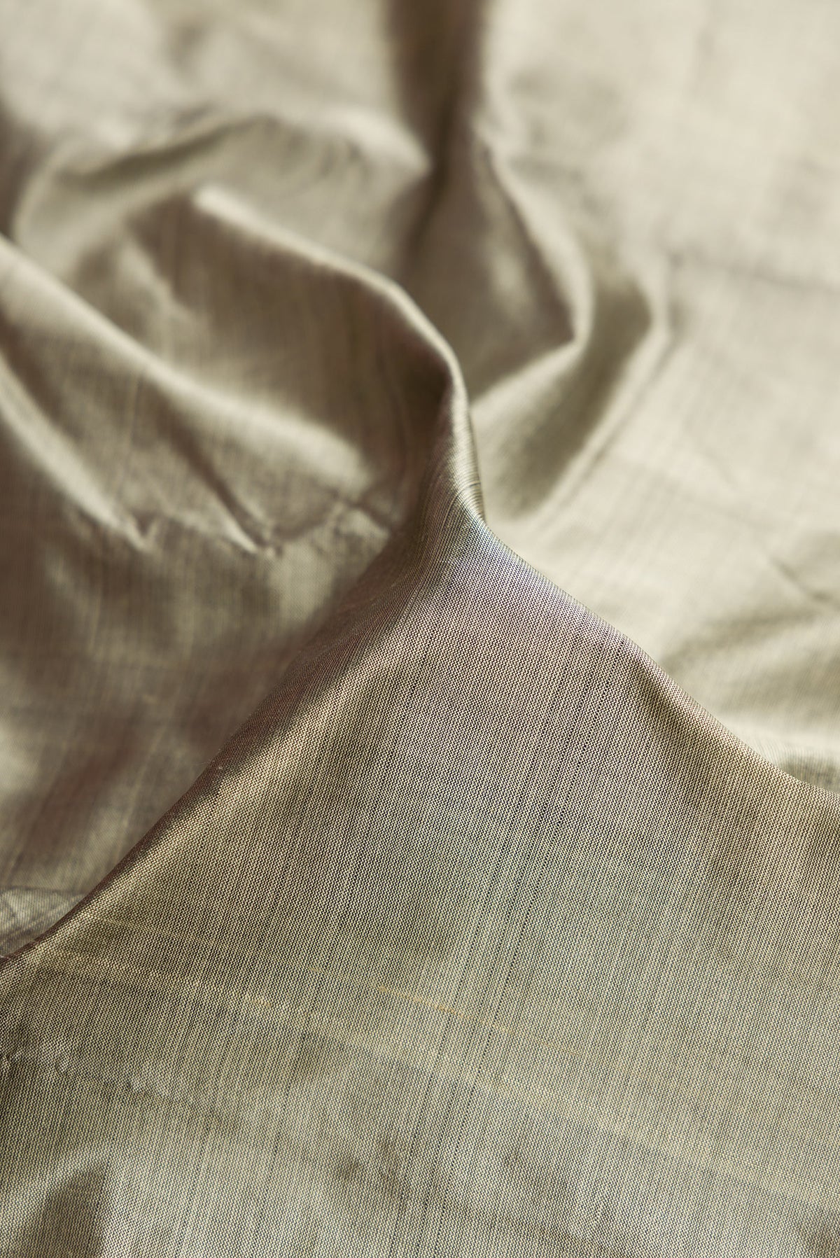 Close up of Grey Dual Tone Kanjivaram Silk Saree with Plain Body and Zari Border.  displaying folds