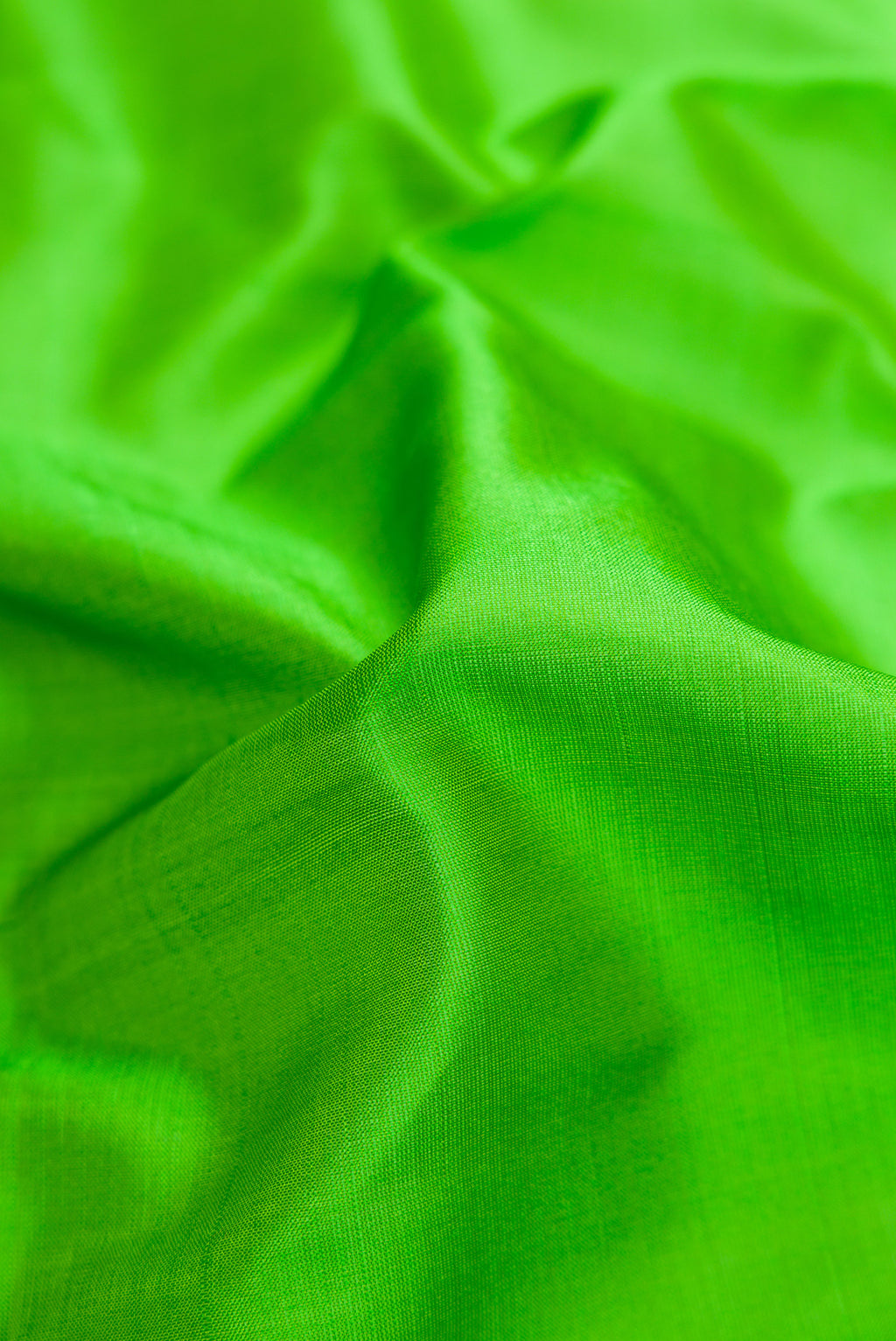 Close up of Green Dual Tone Kanchipuram Silk Saree with Plain Body and Thread Border.  displaying folds