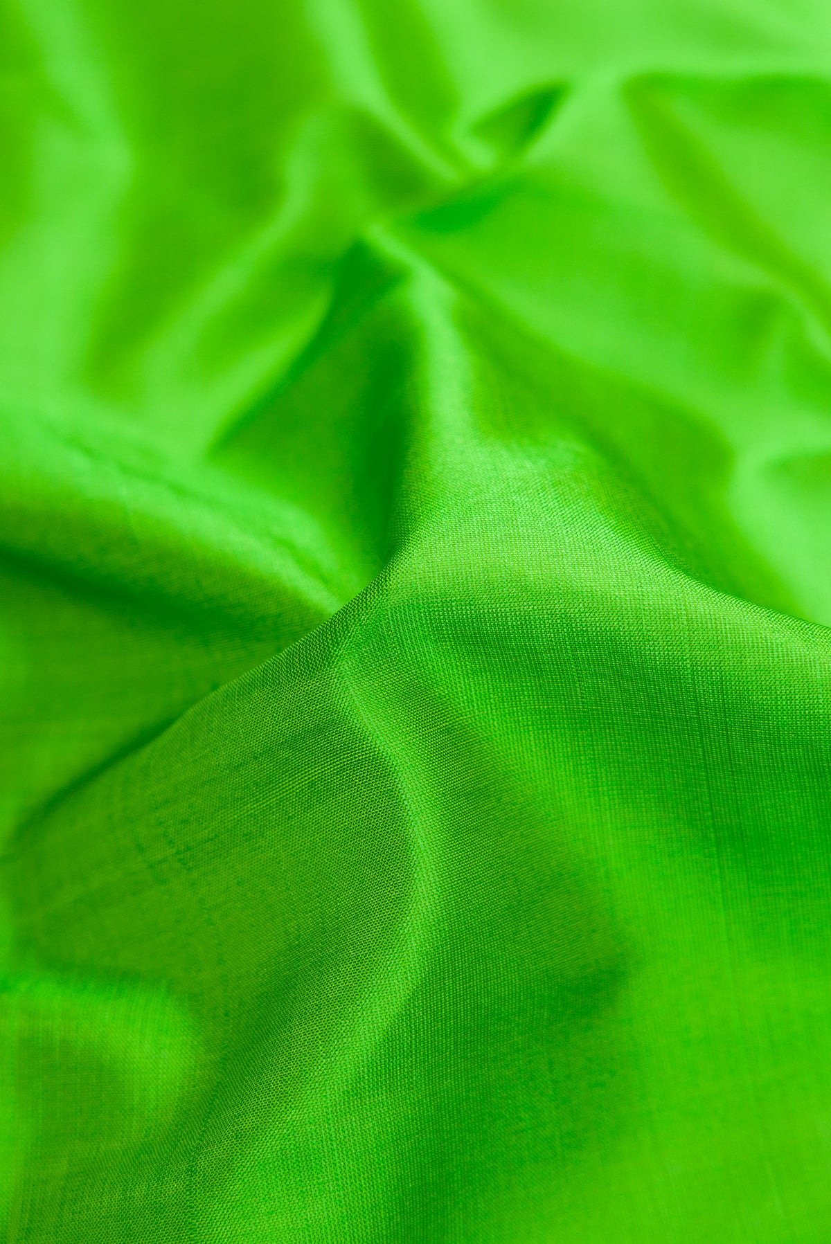 Close up of Green Dual Tone Kanchipuram Silk Saree with Plain Body and Thread Border.  displaying folds
